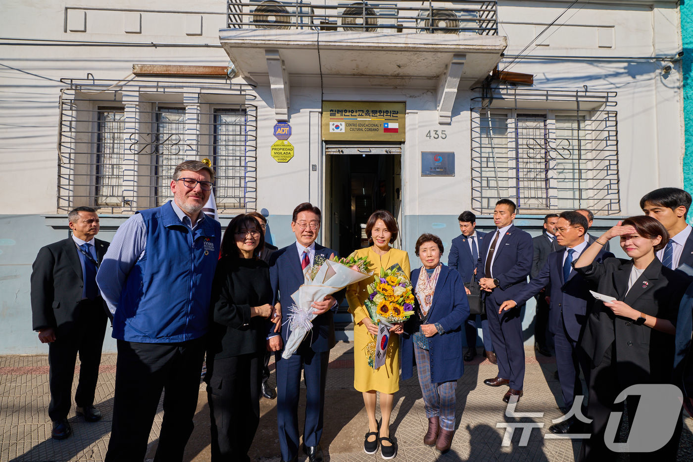 (산티아고(칠레)=뉴스1) 허경 기자 = 이재명 대통령과 김혜경 여사가 30일(현지시간) 칠레 산티아고 서울의 거리를 방문해 칠레한인교육문화회관 관계자들과 기념촬영을 하고 있다. …