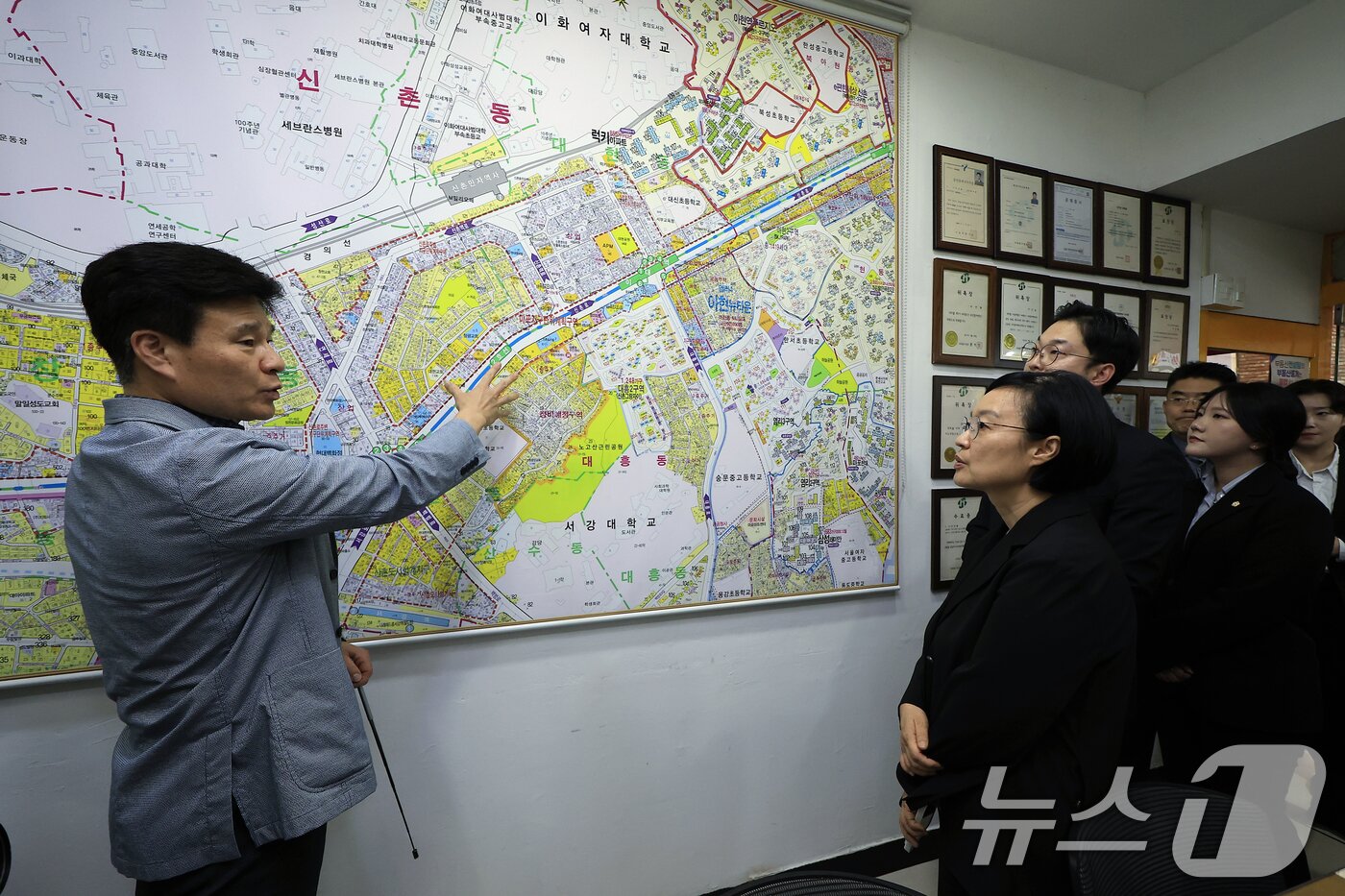 본문 이미지 - 한성숙 국무총리가 4일 오후 서울시 서대문구 신촌 대학가 원룸 밀집지역 내 부동산을 방문해 이선용 공인중개사에게 관내 지역도를 이용한 원룸촌 등에 대한 설명을 듣고 있다. 2026.7.4 ⓒ 뉴스1 박정호 기자