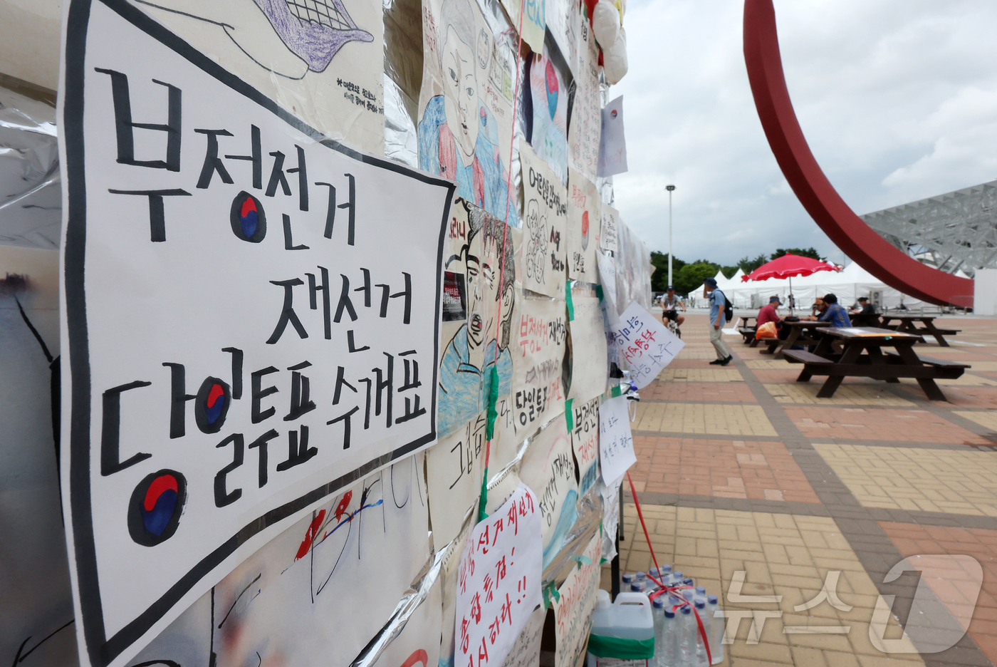 (서울=뉴스1) 김진환 기자 = 6·3 지방선거 투표용지 부족사태로 인한 '잠실 봉쇄시위'가 계속되고 있는 5일 서울 송파구 올림픽공원 핸드볼경기장 인근 매표소 건물에 재선거 요구 …