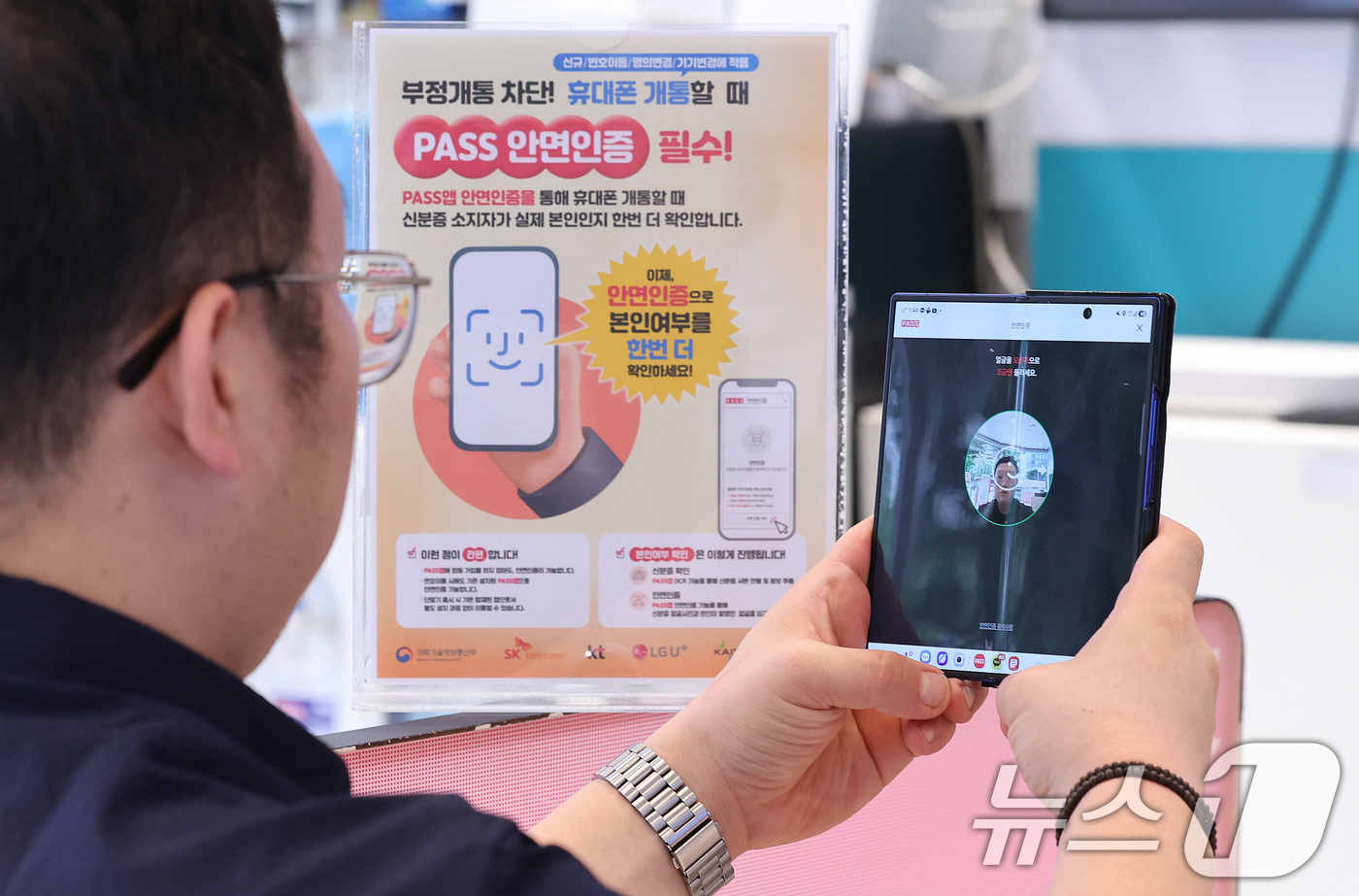 (서울=뉴스1) 박지혜 기자 = 5일 서울 시내의 한 통신사 대리점에서 직원이 휴대전화 개통 시 적용되는 안면인증 절차를 시연하고 있다.이날 과학기술정보통신부에 따르면 SK텔레콤, …