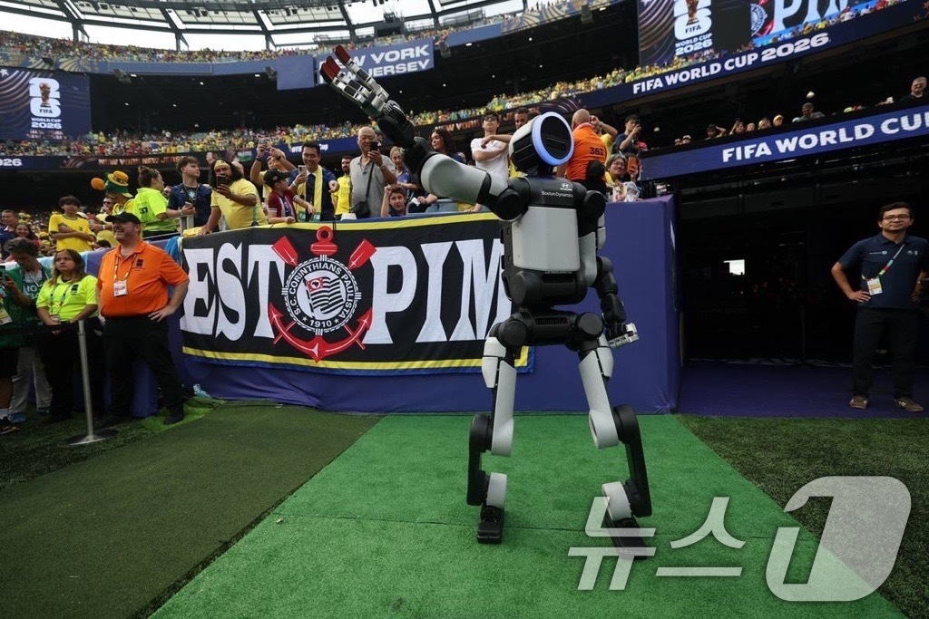 (서울=뉴스1) = 현대자동차는 미국 뉴욕 뉴저지 스타디움에서 열린 '피파 월드컵 2026™' 16강전 하프타임에서 차세대 전동식 휴머노이드 로봇 '아틀라스'가 심판에게 경기구를 …