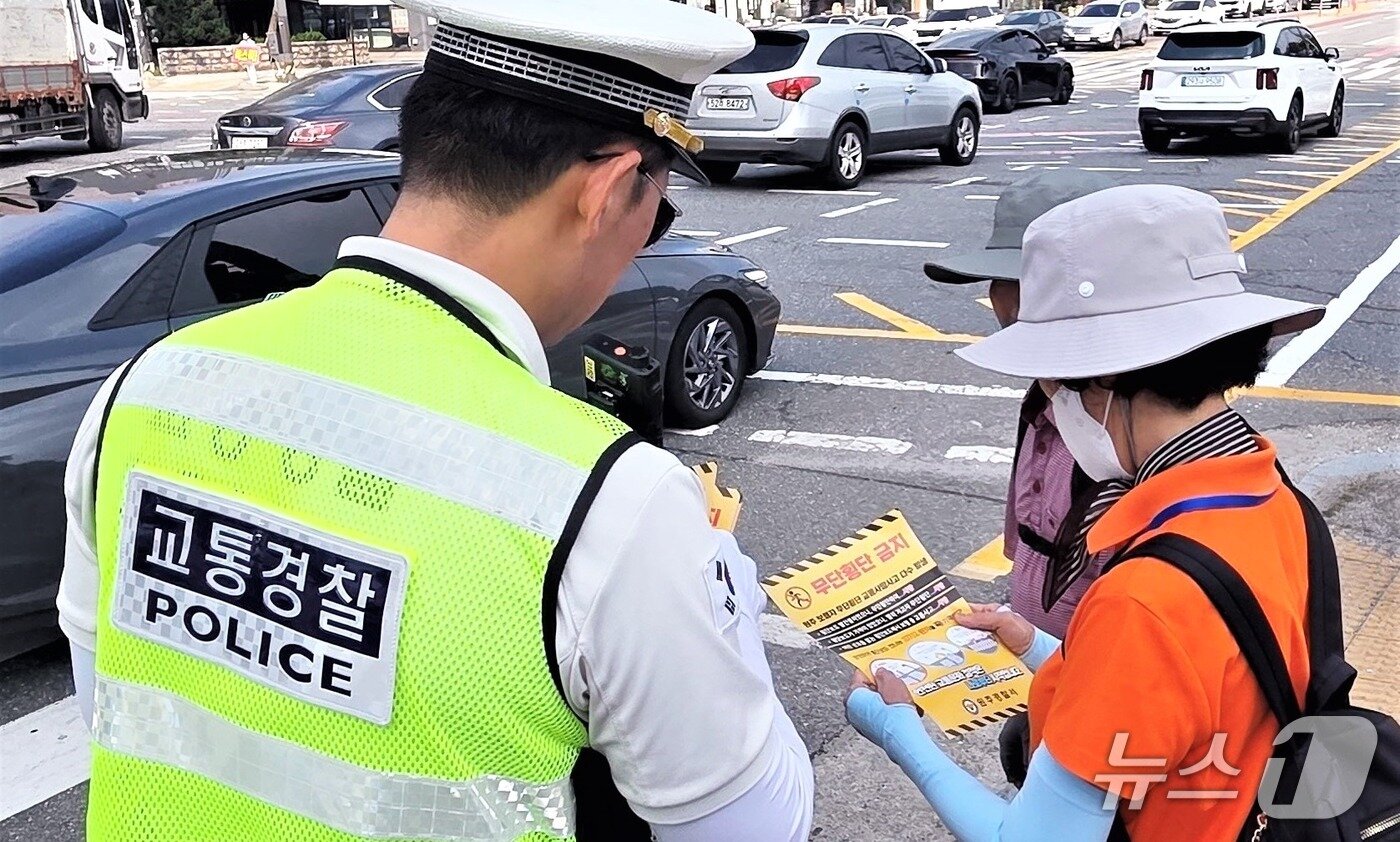 본문 이미지 - ‘보행안전 약속의 날(매월 첫째주 수요일)’을 맞아 강원경찰청 소속 교통경찰관이 보행자 상대로 올바른 횡단 방법 등을 홍보하는 모습.(강원경찰청 제공. 재판매 및 DB금지)/뉴스1
