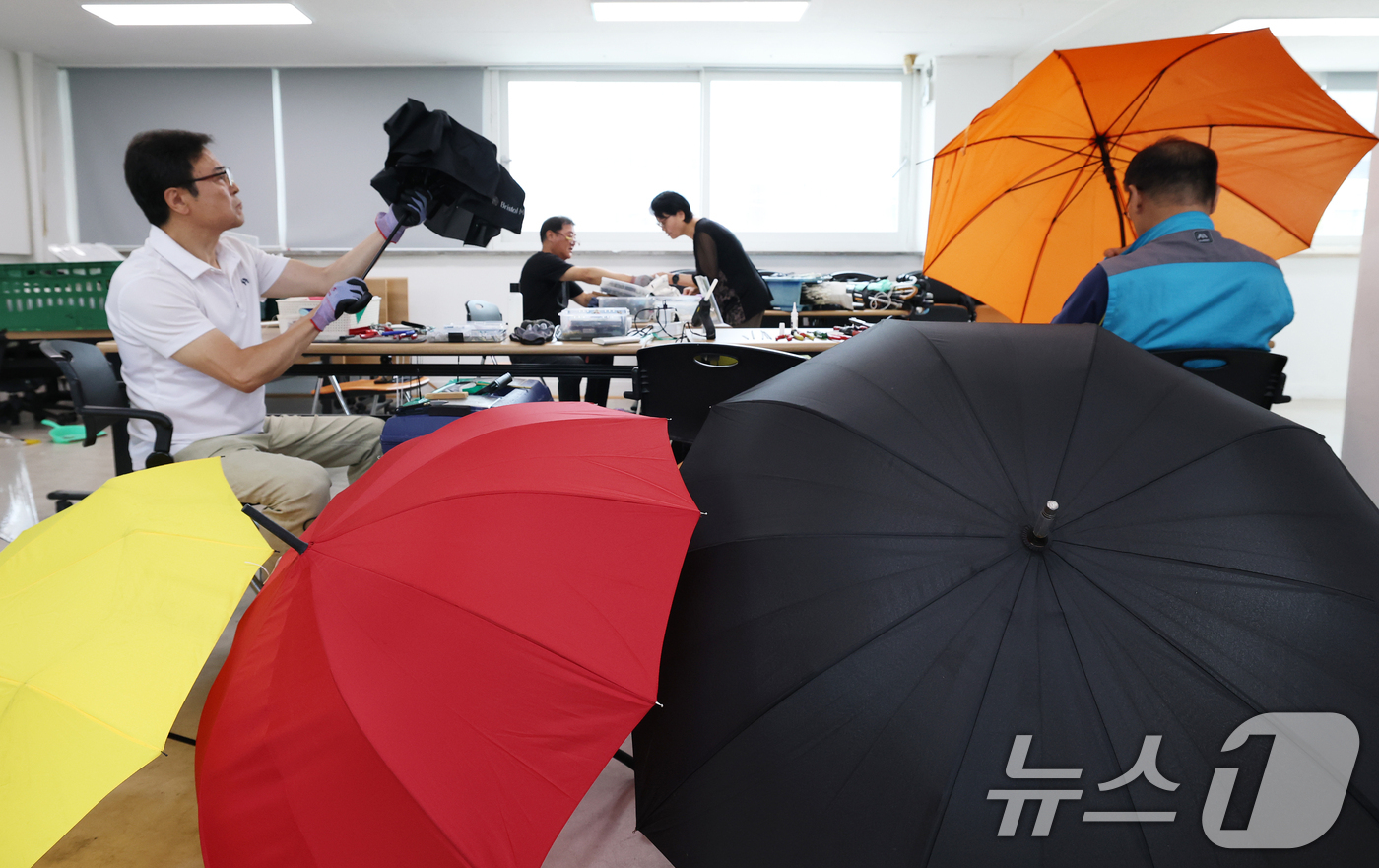 (서울=뉴스1) 오대일 기자 = 7일 서울 송파구 삼전동 주민센터에서 '찾아가는 우산 수리 센터' 관계자들이 고장 난 양산과 우산을 수리하고 있다.우기를 앞둔 주민들의 일상 불편을 …