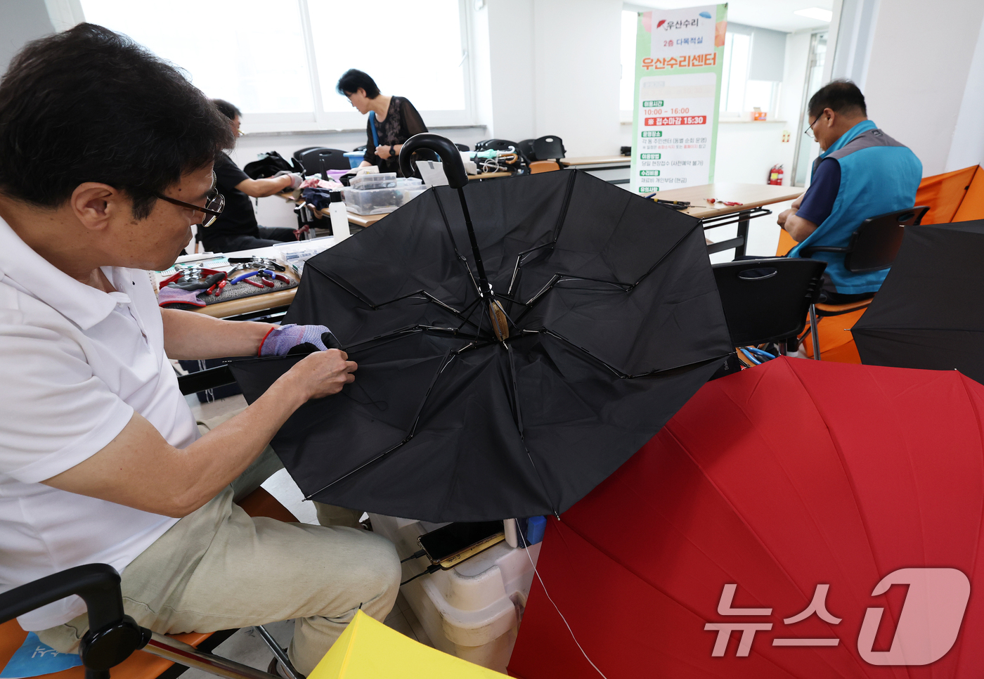 (서울=뉴스1) 오대일 기자 = 7일 서울 송파구 삼전동 주민센터에서 '찾아가는 우산 수리 센터' 관계자들이 고장 난 양산과 우산을 수리하고 있다.우기를 앞둔 주민들의 일상 불편을 …