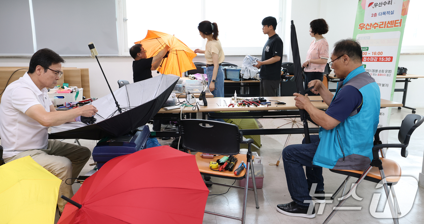 (서울=뉴스1) 오대일 기자 = 7일 서울 송파구 삼전동 주민센터에서 '찾아가는 우산 수리 센터' 관계자들이 고장 난 양산과 우산을 수리하고 있다.우기를 앞둔 주민들의 일상 불편을 …
