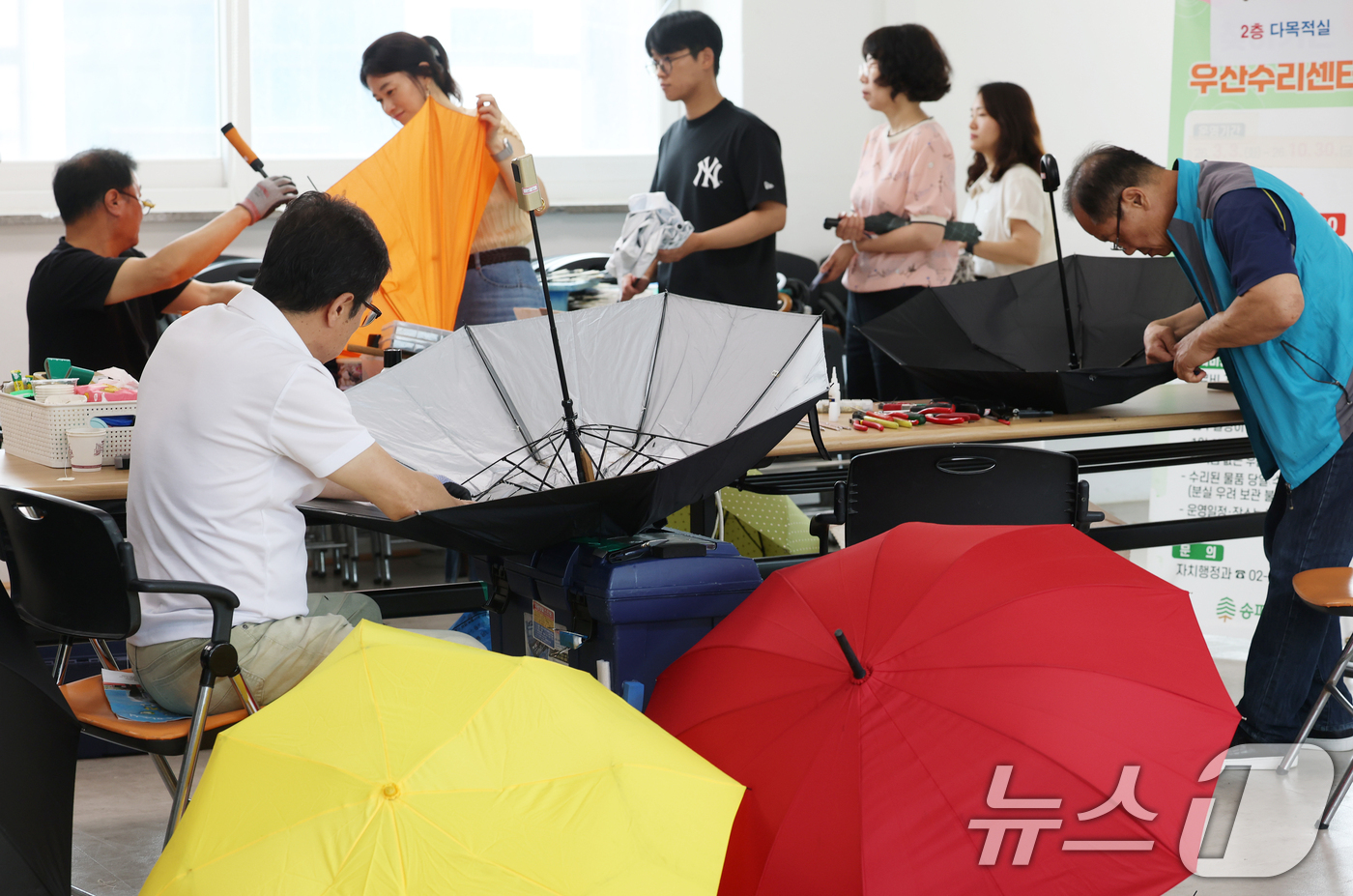 (서울=뉴스1) 오대일 기자 = 7일 서울 송파구 삼전동 주민센터에서 '찾아가는 우산 수리 센터' 관계자들이 고장 난 양산과 우산을 수리하고 있다.우기를 앞둔 주민들의 일상 불편을 …