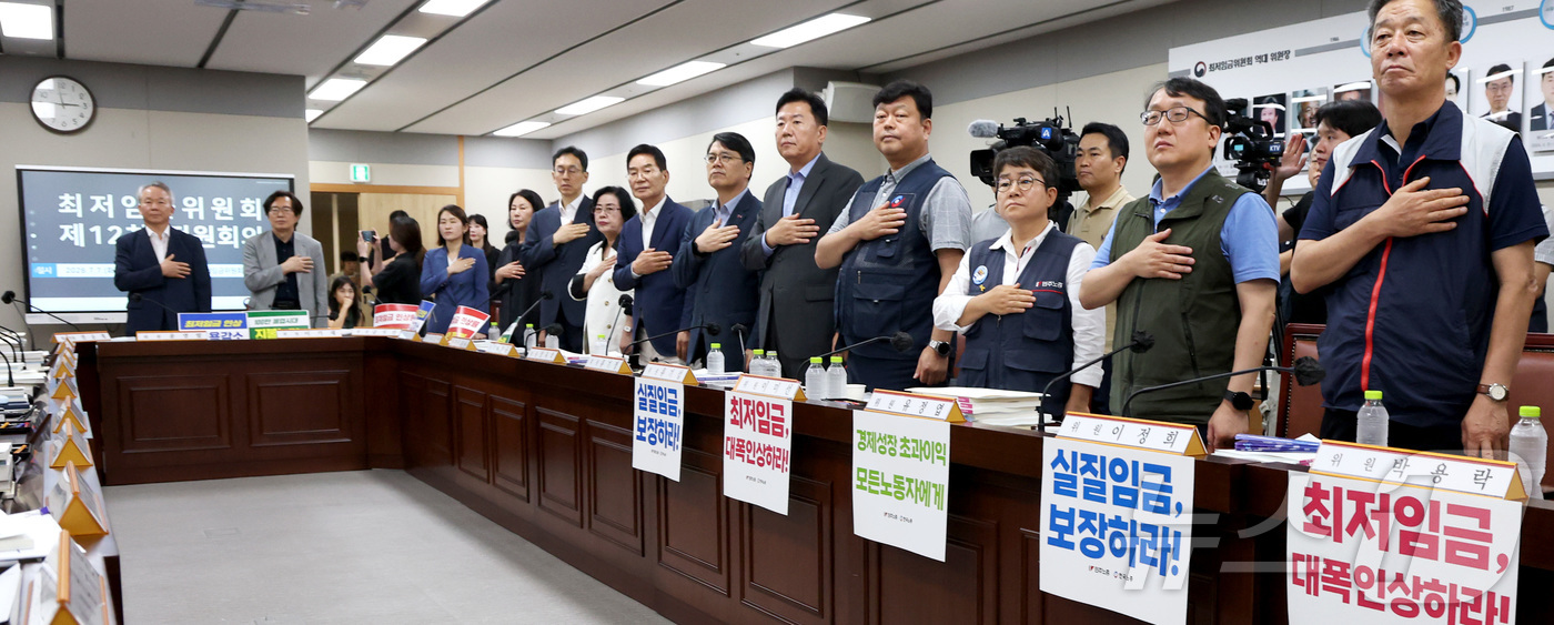 (세종=뉴스1) 김기남 기자 = 7일 세종시 정부세종청사 최저임금위원회에서 열린 2027년도 최저임금위원회 12차 전원회의에서 노·사위원들이 굳은 표정으로 회의를 시작하며 국민의례 …