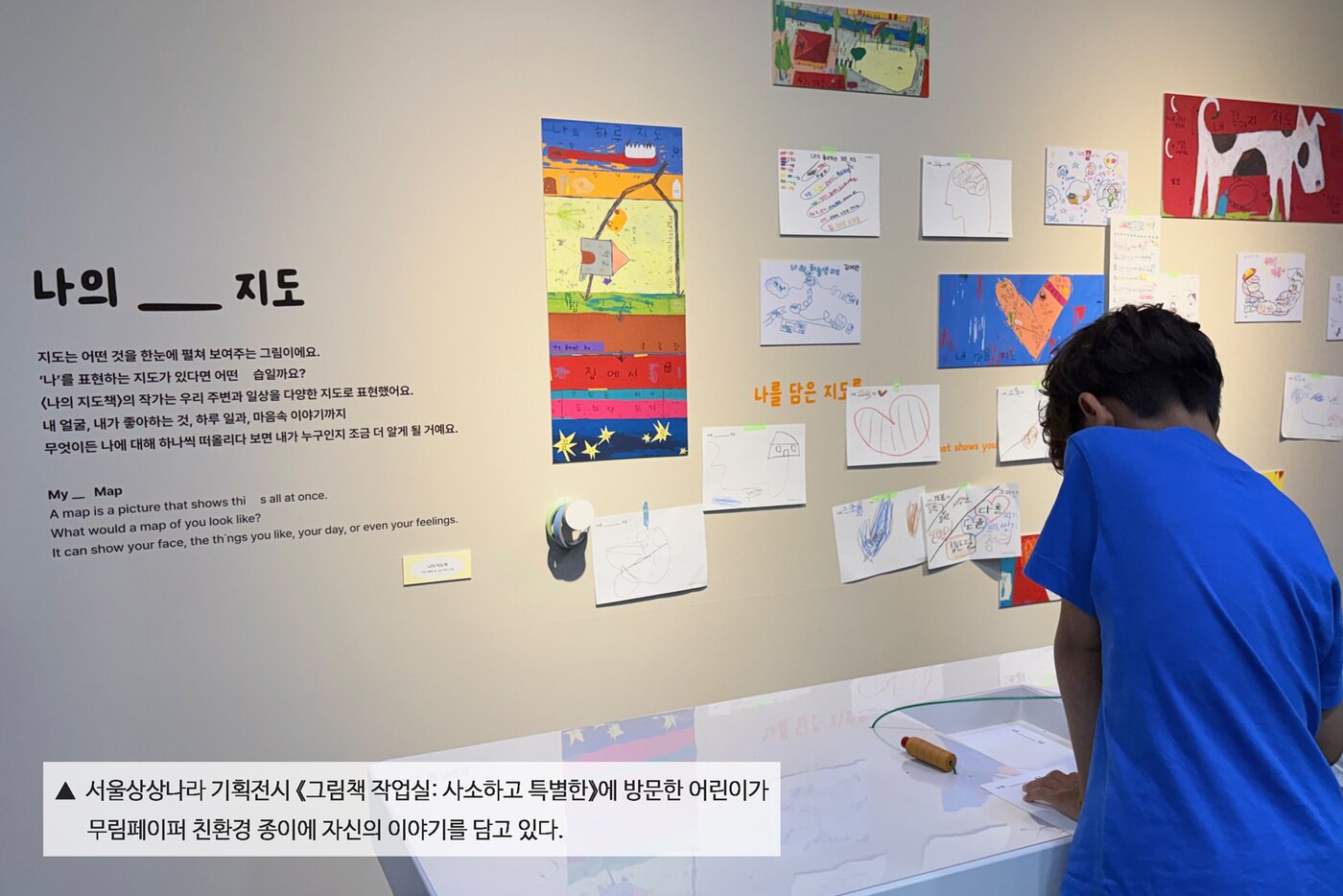 본문 이미지 - 서울상상나라 기획전시 그림책 작업실: 사소하고 특별한에 방문한 어린이가 무림페이퍼 친환경 종이에 자신의 이야기를 담고 있다.(무림페이퍼 제공)