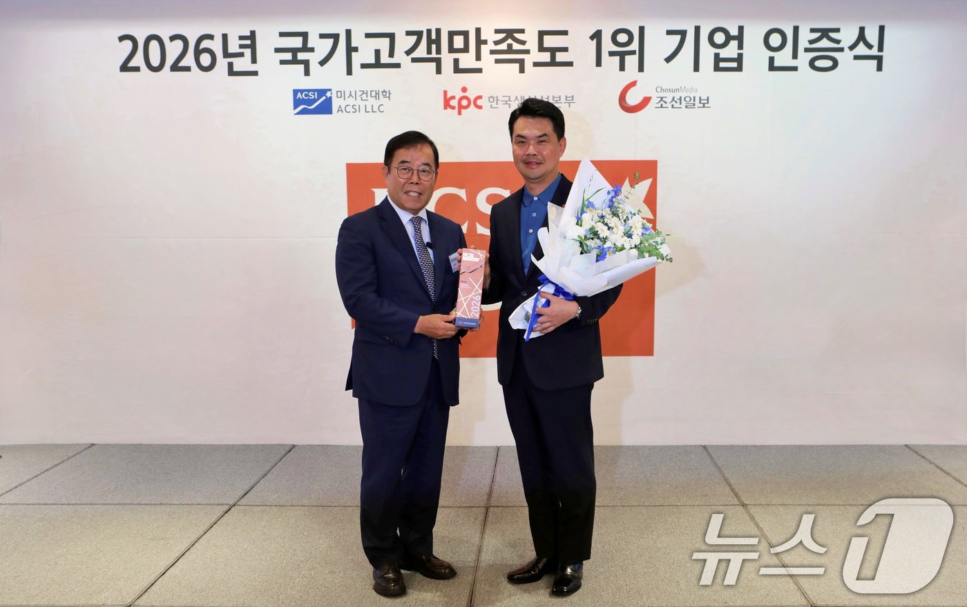 (서울=뉴스1) = 김상우 롯데백화점 영업본부장(오른쪽)이 8일 서울 중구 롯데호텔 서울에서 열린 2026 국가고객만족도(NCSI) 1위 기업 인증식에서 박성중 한국생산성본부 회장 …