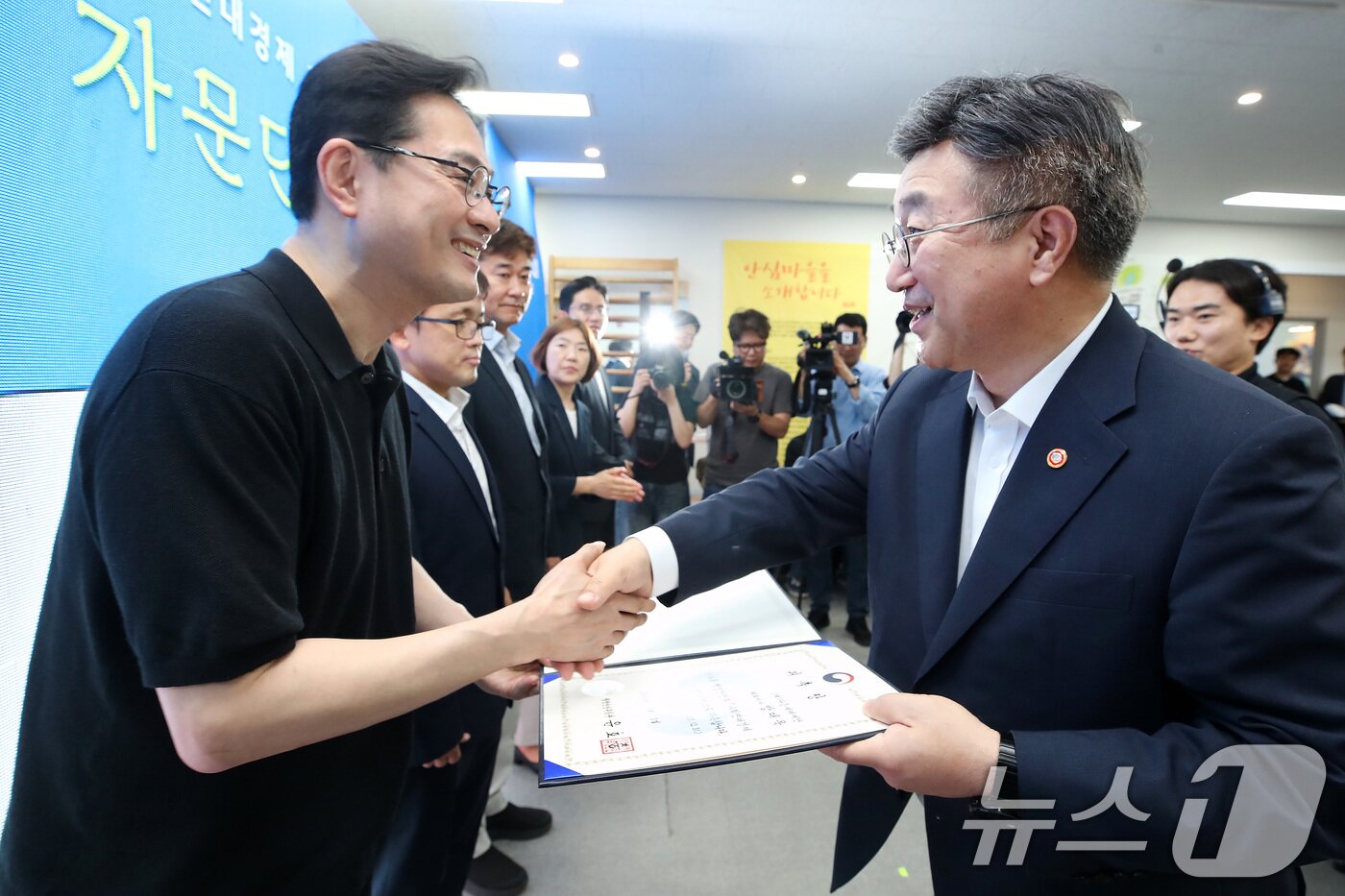 본문 이미지 - 윤호중 행정안전부 장관(오른쪽)이 8일 오후 대구 동구 사회적기업 식스에프 율하점에서 열린 행정안전부·신한금융그룹 사회연대경제 혁신모델 자문단 위촉식에서 위촉장을 전달하고 있다. 2026.7.8 ⓒ 뉴스1 공정식 기자
