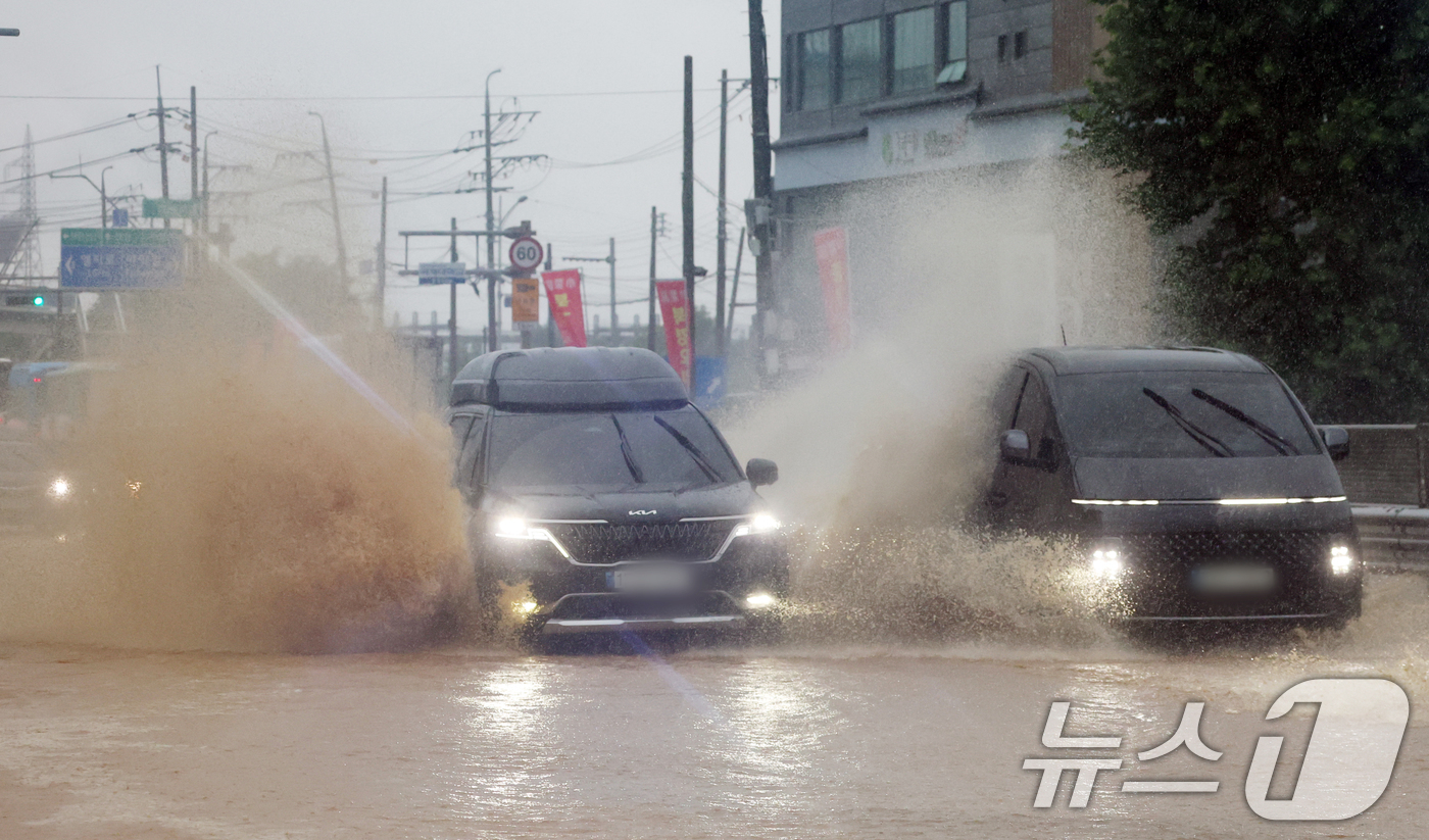 (오산=뉴스1) 김영운 기자 = 수도권에 많은 비가 내린 9일 경기 오산시의 한 도로가 침수돼 차량이 물보라를 일으키며 주행하고 있다. 2026.7.9/뉴스1