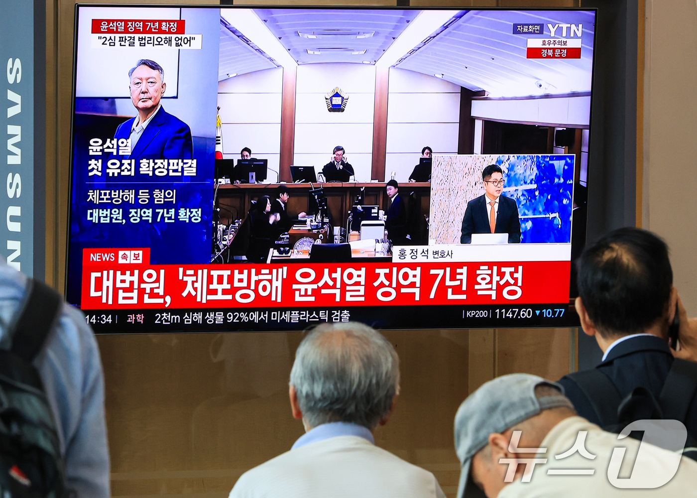 (서울=뉴스1) 이호윤 기자 = 9일 서울 중구 서울역 대합실에서 시민들이 윤석열 전 대통령의 고위공직자범죄수사처 체포방해 등 혐의 사건 상고심 선고 생중계를 지켜보고 있다.대법원 …