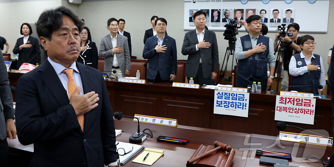 본문 이미지 - 권순원 최저임금위원회 위원장을 비롯한 노·사 위원들이 9일 세종시 정부세종청사 최저임금위원회에서 열린 2027년도 최저임금위원회 13차 전원회의에 앞서 국민의례를 하고 있다. 2026.7.9 ⓒ 뉴스1 김기남 기자