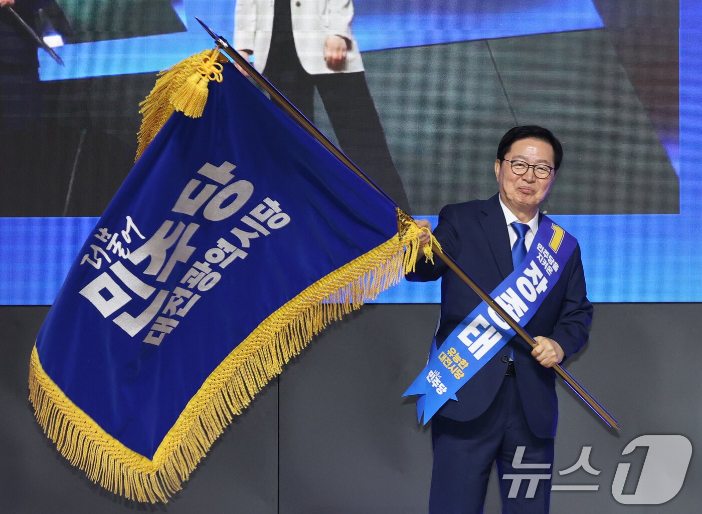 본문 이미지 - 지난 1일 대전 유성구 대전컨벤션센터에서 열린 더불어민주당 대전시당 정기당원대회에서 시당위원장으로 선출된 장종태 신임 시당위원장이 당기를 흔들어 보이고 있다. 2026.8.1 ⓒ 뉴스1 김기태 기자