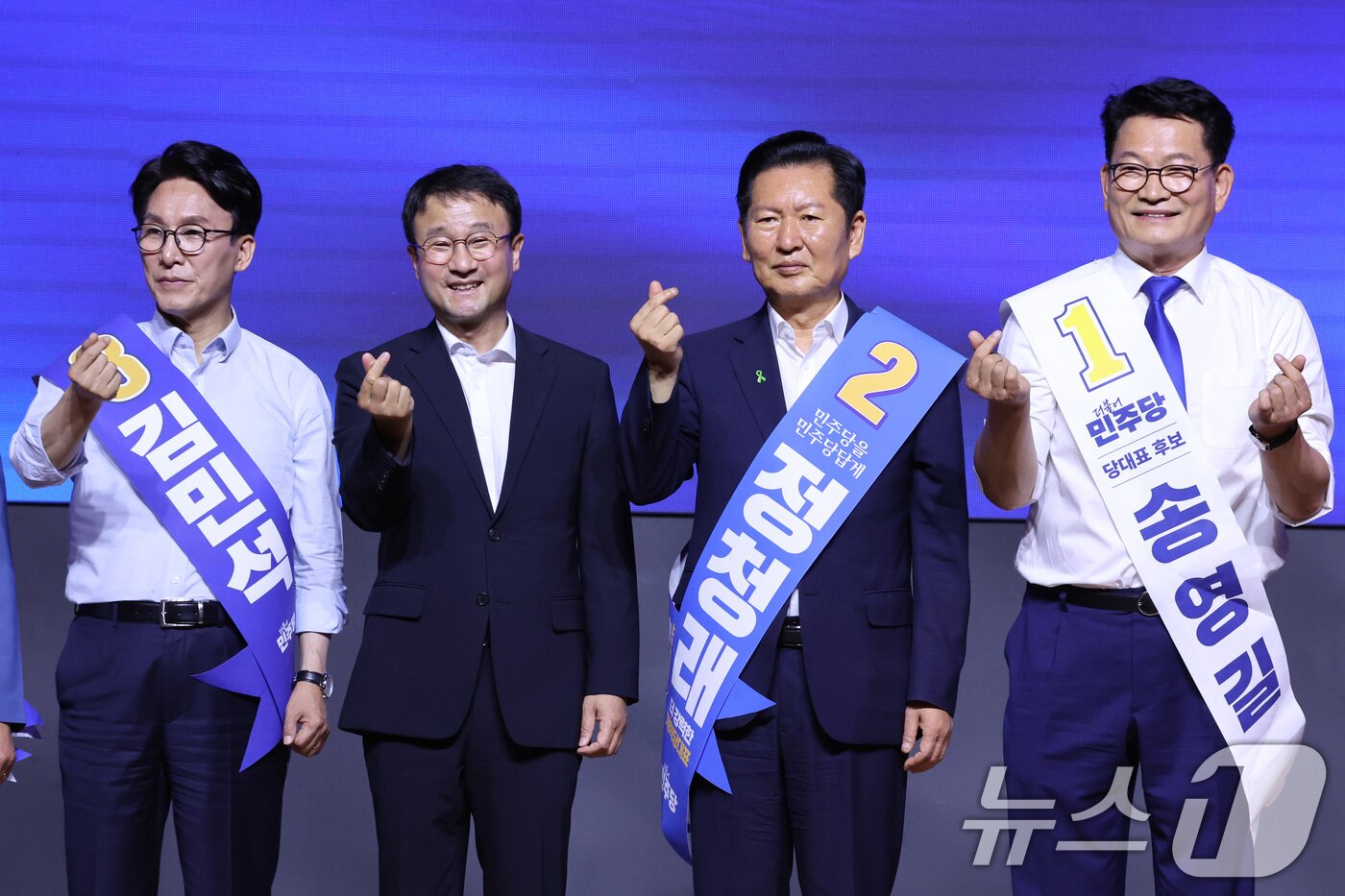 본문 이미지 - 한병도 더불어민주당 당대표 직무대행 겸 원내대표가 1일 대전 유성구 대전컨벤션센터에서 열린 당대표·최고위원 합동연설회에서 당대표 후보인 김민석, 정청래, 송영길 의원과 손하트를 만들고 있다. 2026.8.1 ⓒ 뉴스1 신웅수 기자