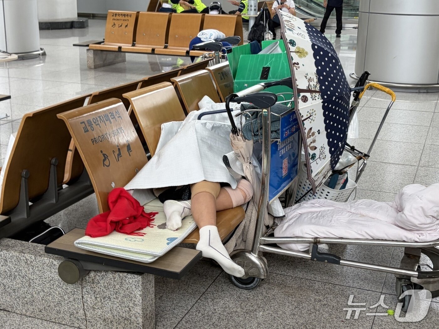 본문 이미지 - 인천국제공항 여객터미널에서 장기 체류 중인 노숙인이 의자에 누워 휴식을 취하고 있다.(독자 제공)2026.8.10/뉴스1