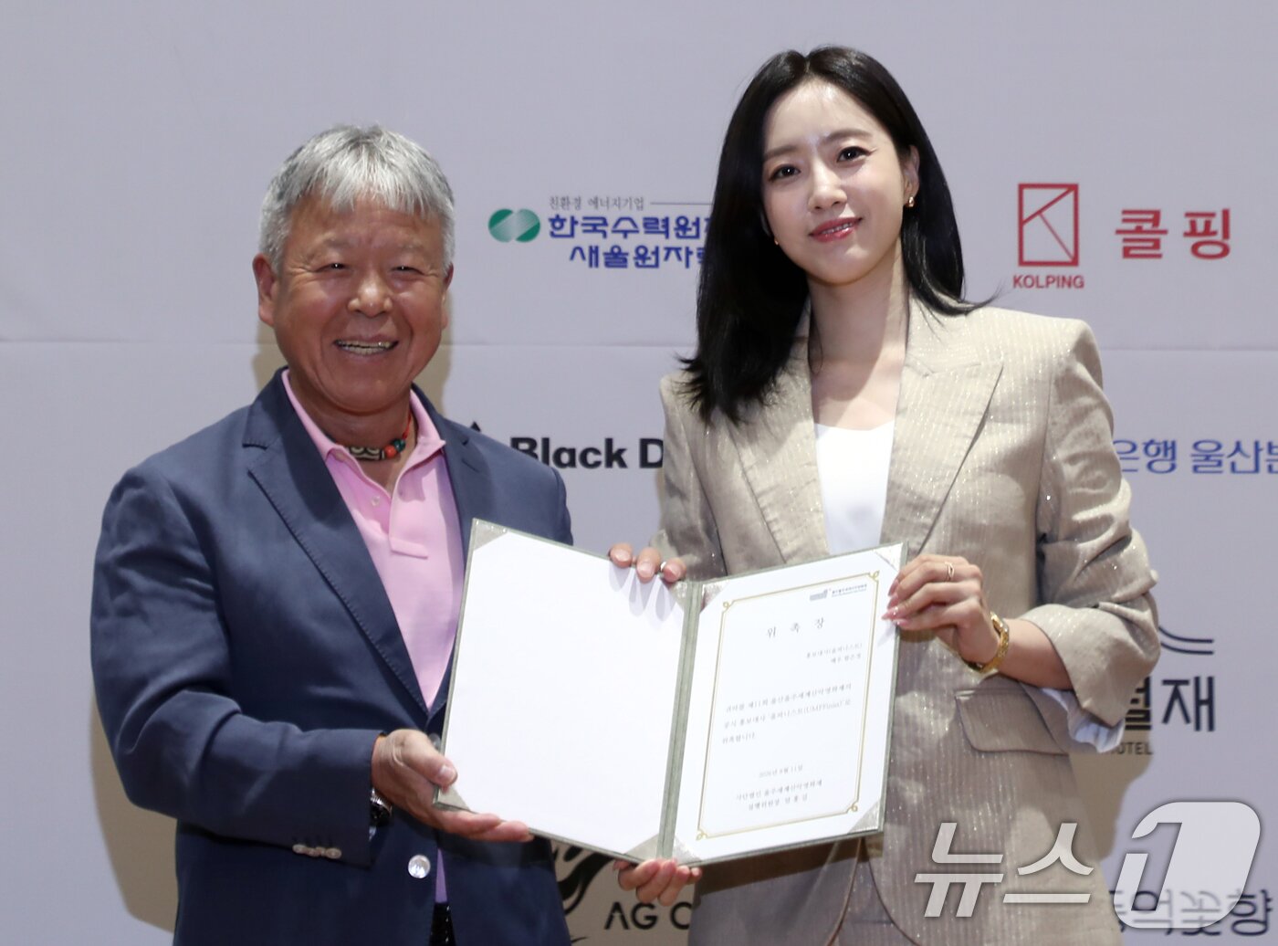 본문 이미지 - 11일 울산시청 시민홀에서 열린 제11회 울산울주세계산악영화제 기자회견에서 엄홍길 집행위원장이 배우 함은정에게 홍보대사 위촉장을 수여하고 있다. 2026.8.11 ⓒ 뉴스1 조민주 기자