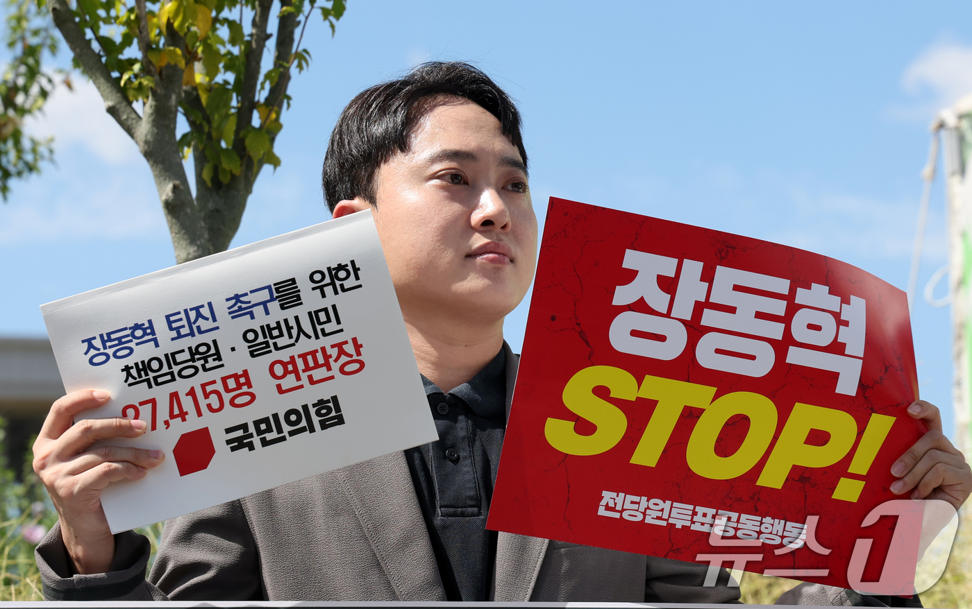 (서울=뉴스1) 황기선 기자 = 박인규 국민의힘 책임당원이 11일 오후 서울 여의도 국회 앞에서 장동혁 대표 퇴진 촉구를 위한 책임당원·일반시민 연판장을 들어보고이고 있다. 202 …