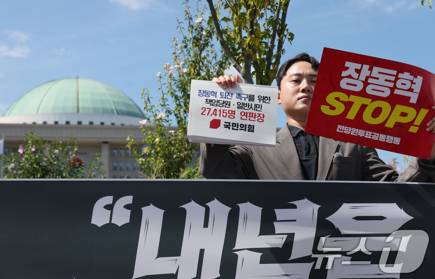 (서울=뉴스1) 황기선 기자 = 박인규 국민의힘 책임당원이 11일 오후 서울 여의도 국회 앞에서 장동혁 대표 퇴진 촉구를 위한 책임당원·일반시민 연판장을 들어보고이고 있다. 202 …
