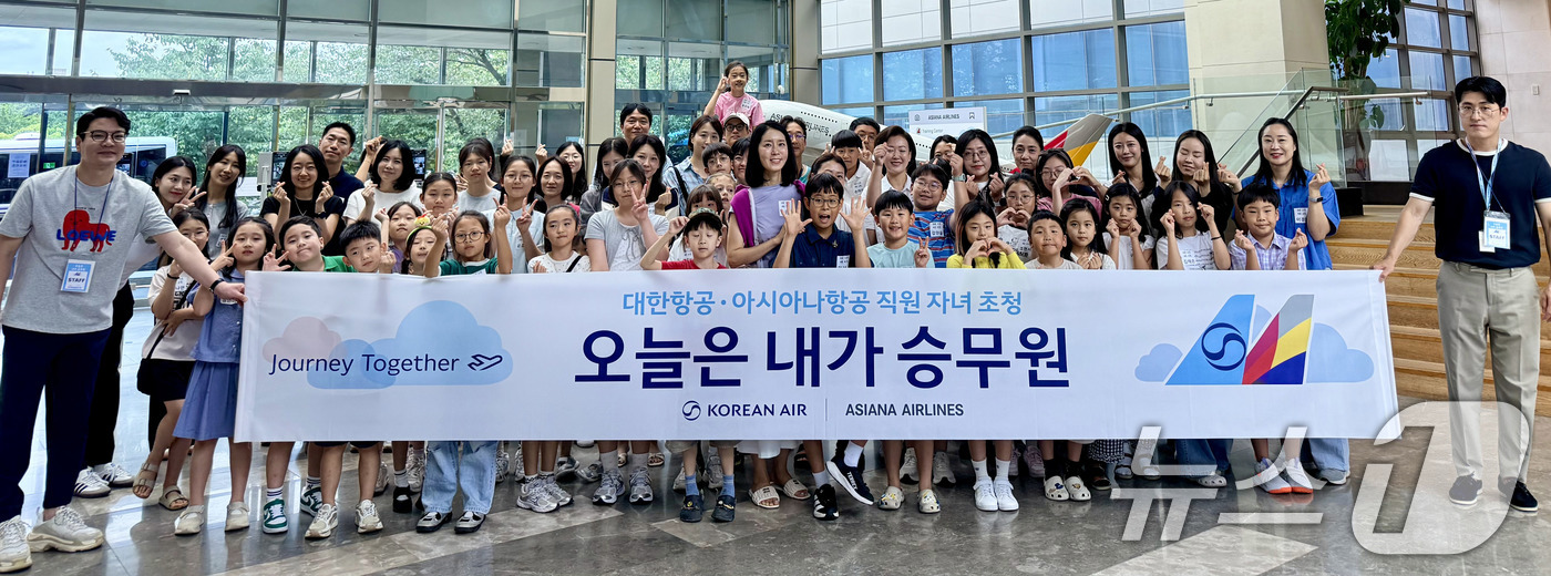 (서울=뉴스1) = 지난 13일 서울 강서구 아시아나항공 객실훈련원에서 열린 '아시아나항공·대한항공 직원 자녀 초청 진로 교육'에서 참가 어린이 등이 기념촬영을 하고 있다. (아시 …
