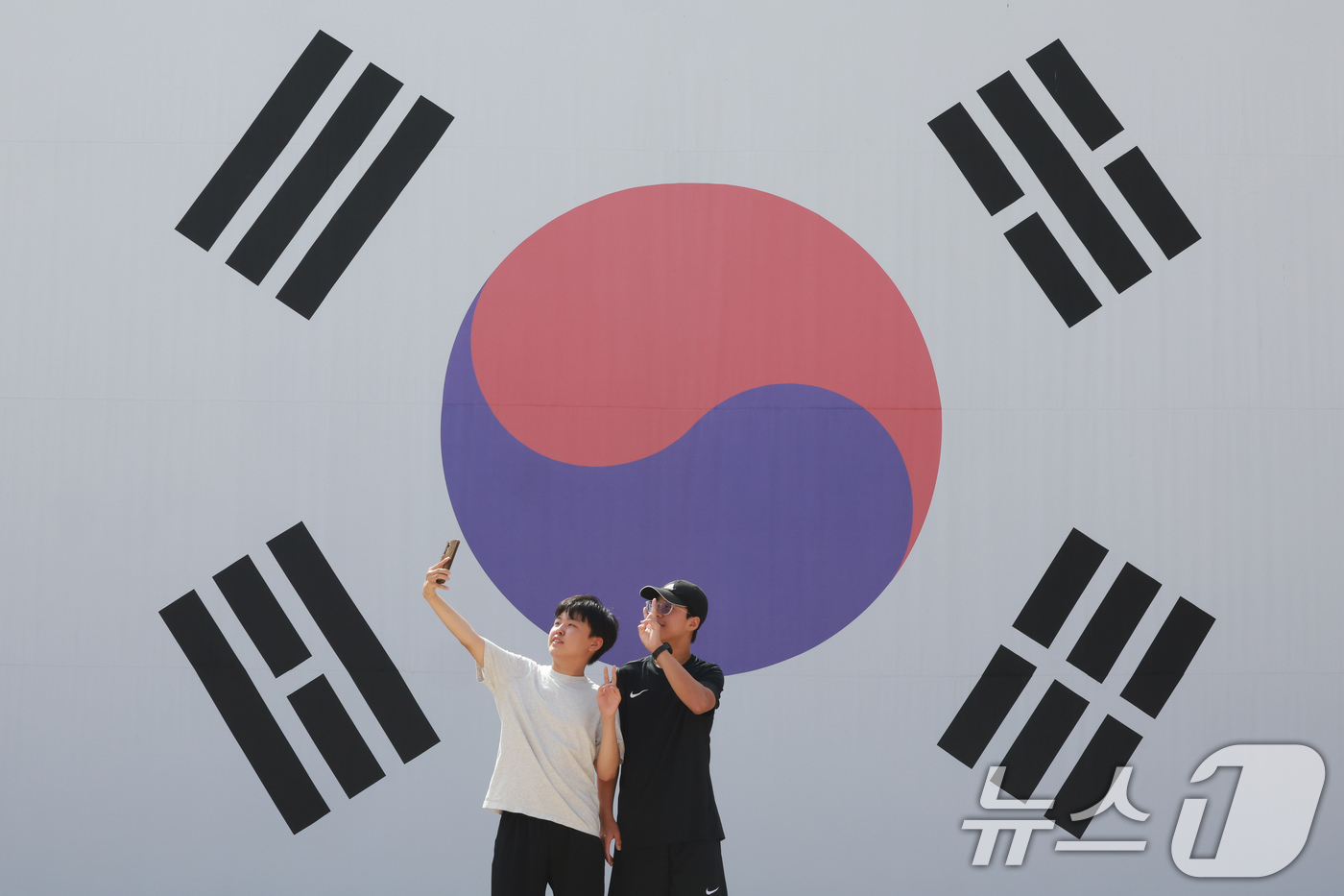 (서울=뉴스1) 이호윤 기자 = 제81주년 광복절을 하루 앞둔 14일 서울 서대문구 서대문형무소역사관 대형 태극기 앞에서 학생들이 기념촬영을 하고 있다. 2026.8.14/뉴스1