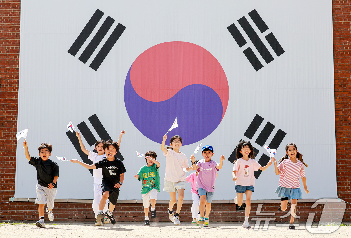 (서울=뉴스1) 이호윤 기자 = 제81주년 광복절을 하루 앞둔 14일 서울 서대문구 서대문형무소역사관 대형 태극기 앞에서 어린이들이 직접 만든 태극기를 흔들며 힘차게 뛰고 있다. …