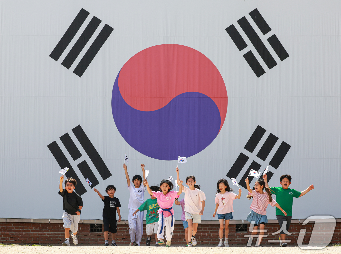 (서울=뉴스1) 이호윤 기자 = 제81주년 광복절을 하루 앞둔 14일 서울 서대문구 서대문형무소역사관 대형 태극기 앞에서 어린이들이 직접 만든 태극기를 흔들며 힘차게 뛰고 있다. …
