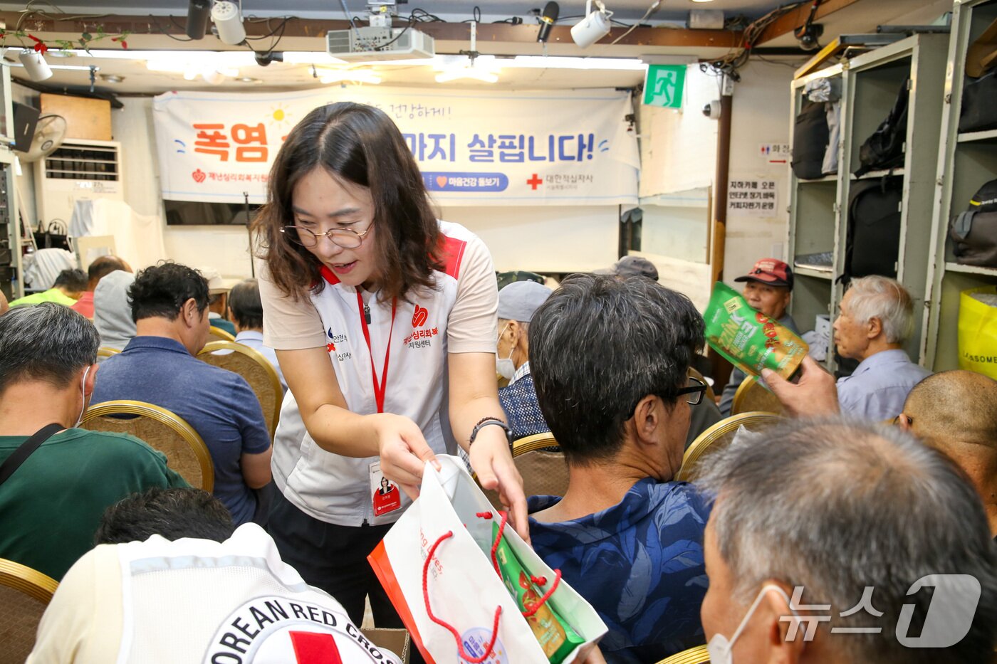 본문 이미지 - 적십자 관계자가 서울역 드림씨티에서 폭염 극복을 돕기 위해 마련된 폭염 대응 키트(구호 물품)를 전달하고 있다.(대한적십자사 서울지사 제공)