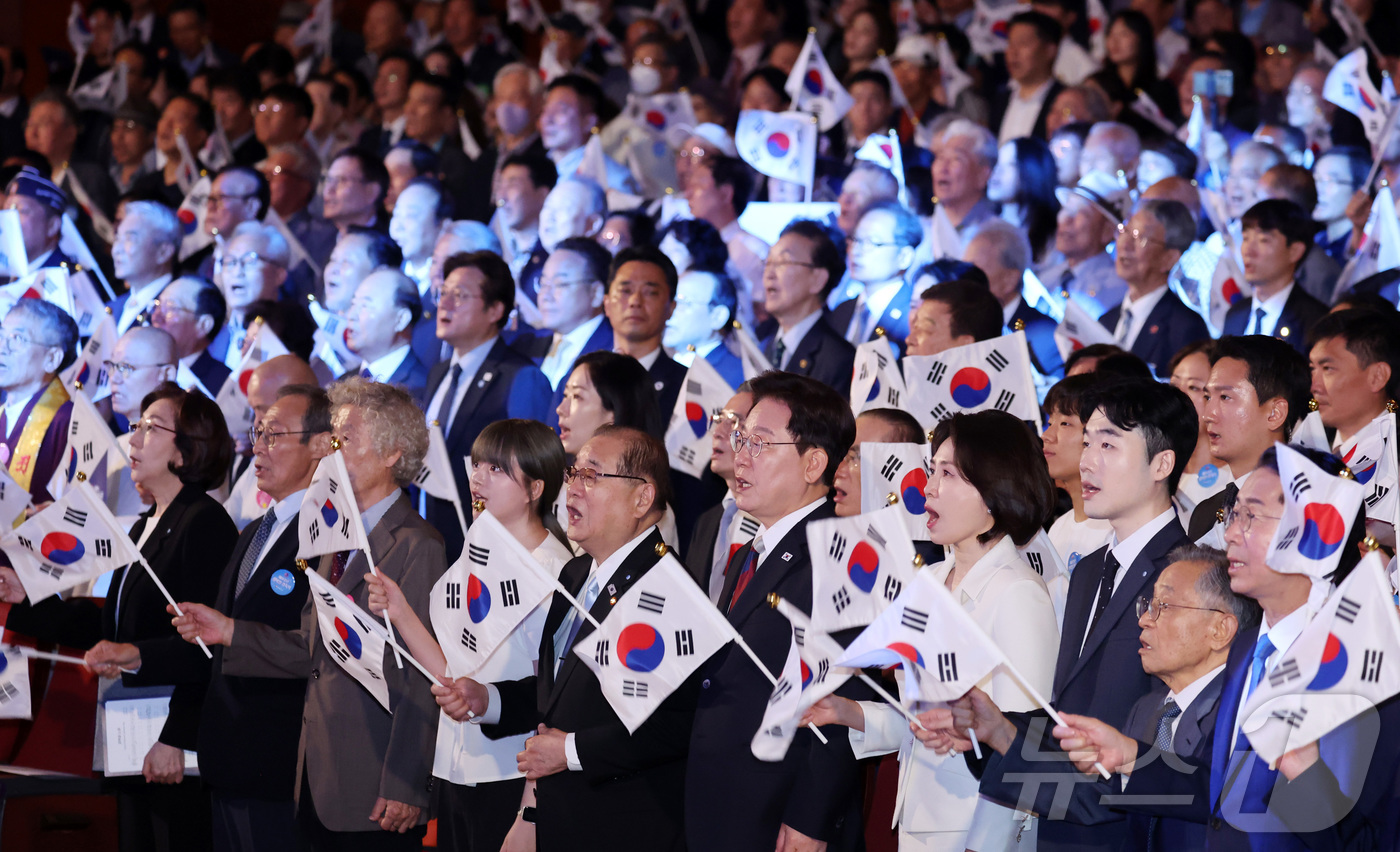(서울=뉴스1) 이재명 기자 = 이재명 대통령과 김혜경 여사가 15일 서울 종로구 세종문화회관에서 열린 제81주년 광복절 경축식에서 광복절 노래를 제창하며 태극기를 흔들고 있다. …