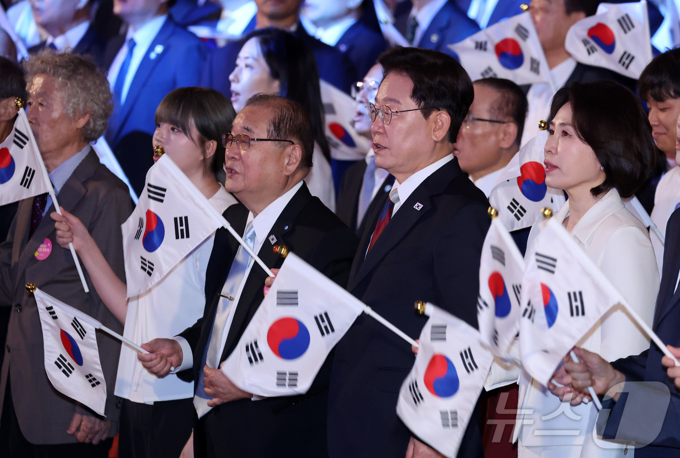 (서울=뉴스1) 이재명 기자 = 이재명 대통령과 김혜경 여사가 15일 서울 종로구 세종문화회관에서 열린 제81주년 광복절 경축식에서 광복절 노래를 제창하며 태극기를 흔들고 있다. …