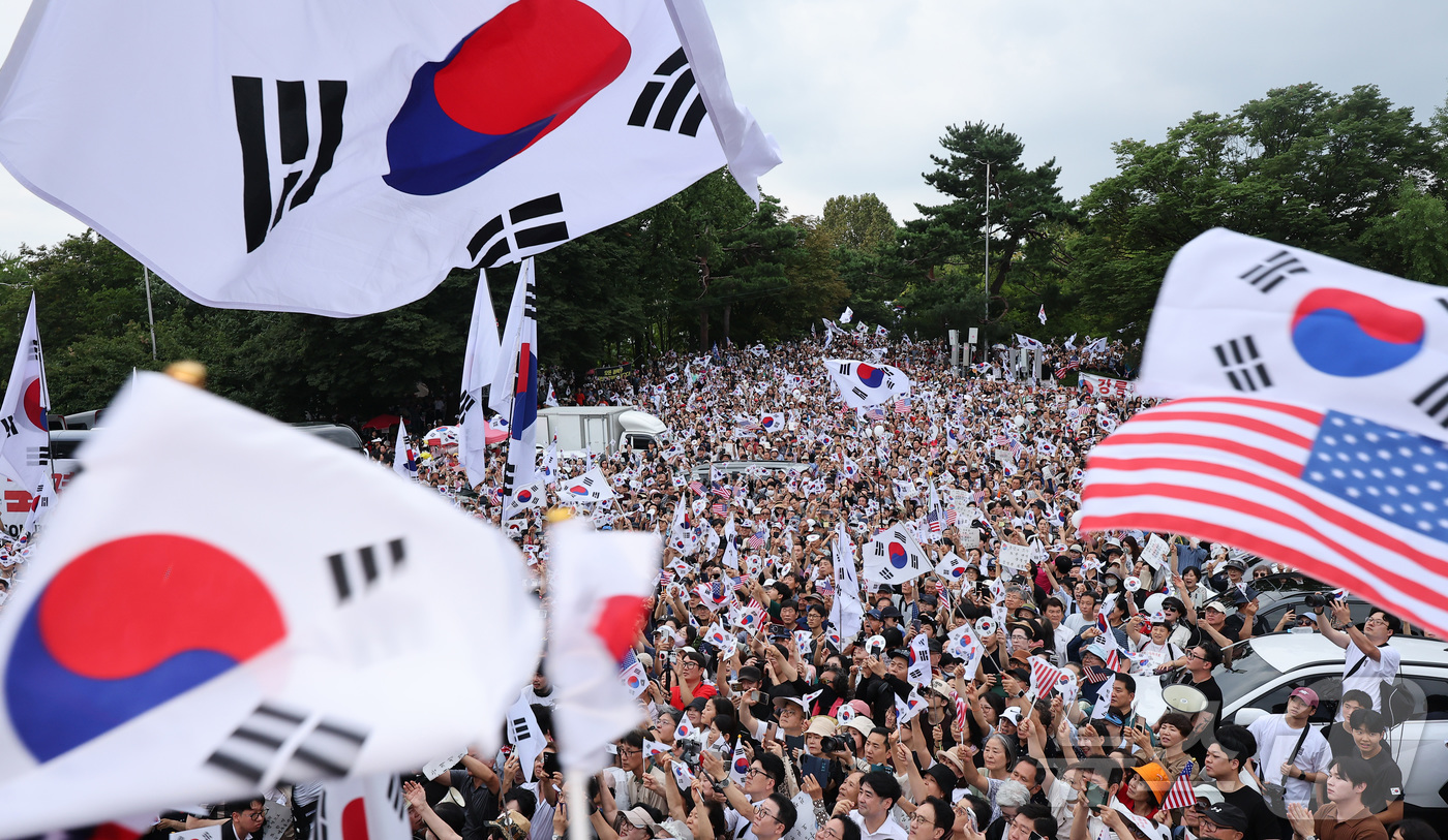 (서울=뉴스1) 김성진 기자 = 광복절인 15일 서울 송파구 올림픽공원 핸드볼경기장에서 열린 투표 용지 부족 사태 관련 참정권 수호 집회에 참석한 참가자들이 태극기를 흔들고 있다. …