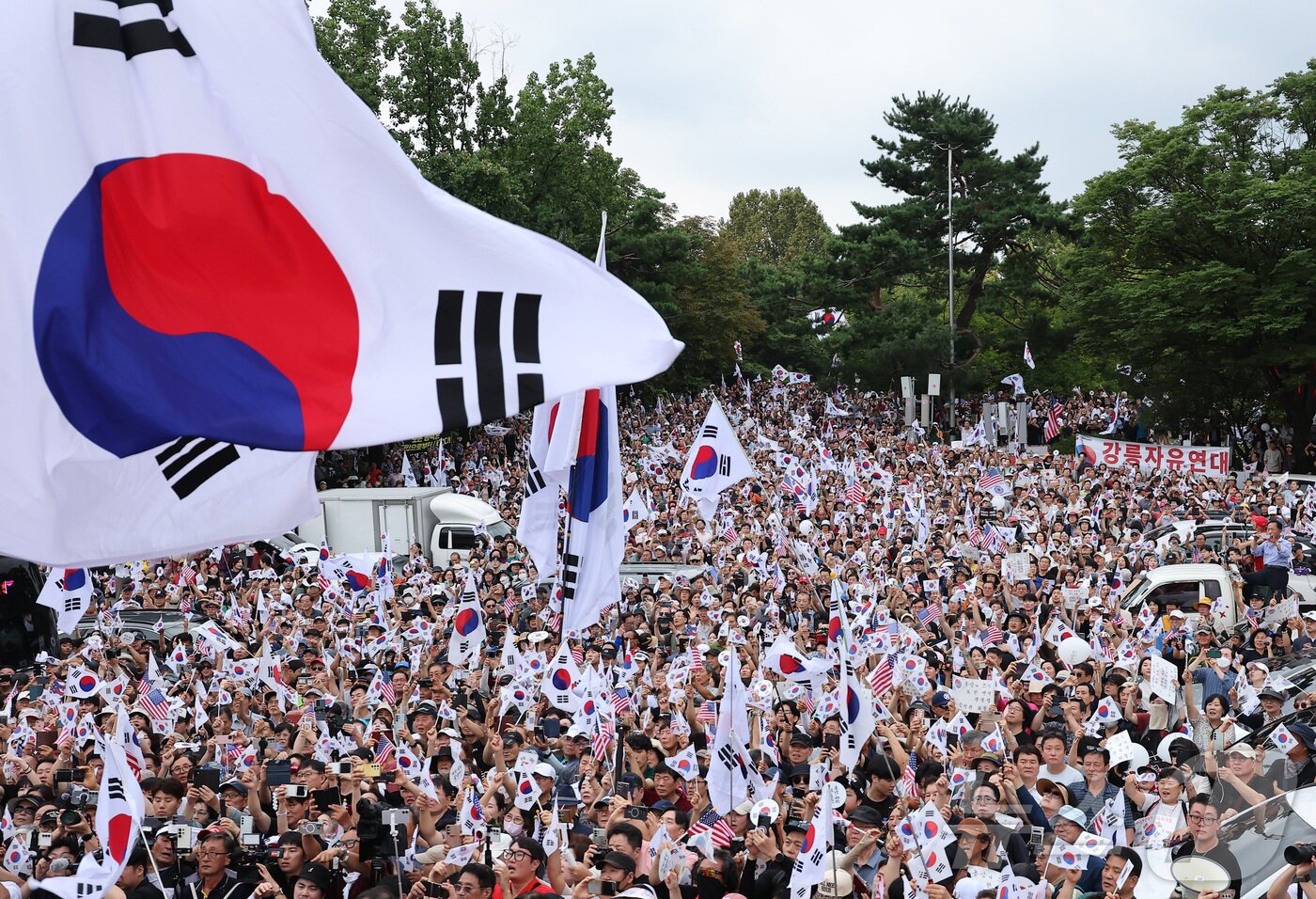 본문 이미지 - 광복절인 15일 서울 송파구 올림픽공원 핸드볼경기장에서 열린 투표 용지 부족 사태 관련 참정권 수호 집회에 참석한 참가자들이 태극기를 흔들고 있다. 2026.8.15 ⓒ 뉴스1 김성진 기자