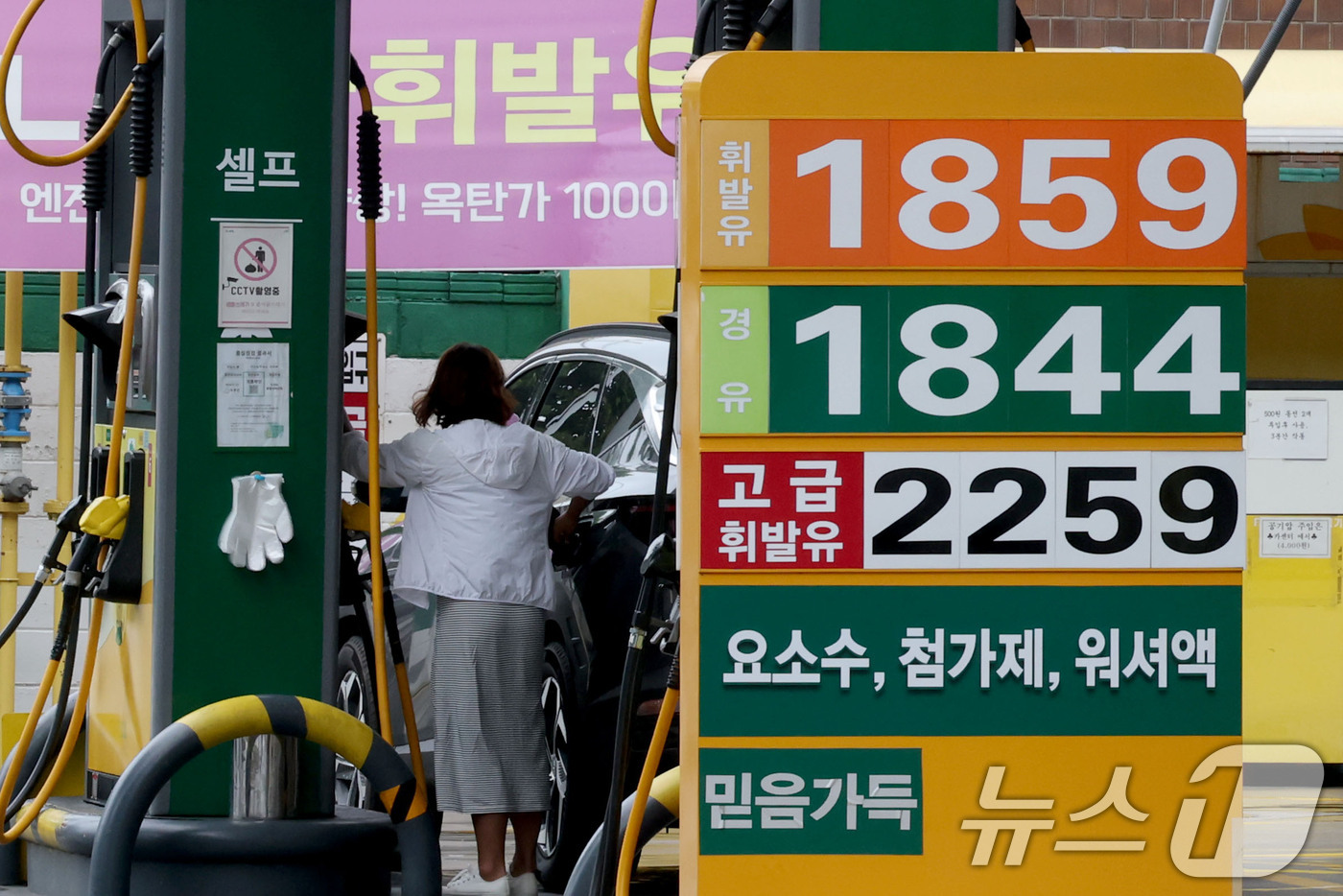 (서울=뉴스1) 이광호 기자 = 전국 주유소 기름값이 13주 연속 하락하며 휘발유와 경유 모두 1천800원 중반대를 유지하고 있는 16일 서울의 한 주유소를 찾은 시민이 주유를 하 …