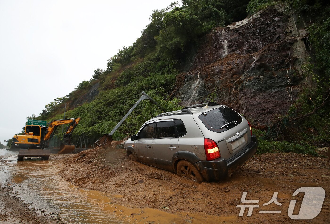 본문 이미지 - 17일 경남 거제시 연초면 송정리 송정터널 인근에서 산사태가 발생해 한 차량이 흘러 내린 토사에 파묻혀 있다. 2026.8.17 ⓒ 뉴스1 윤일지 기자