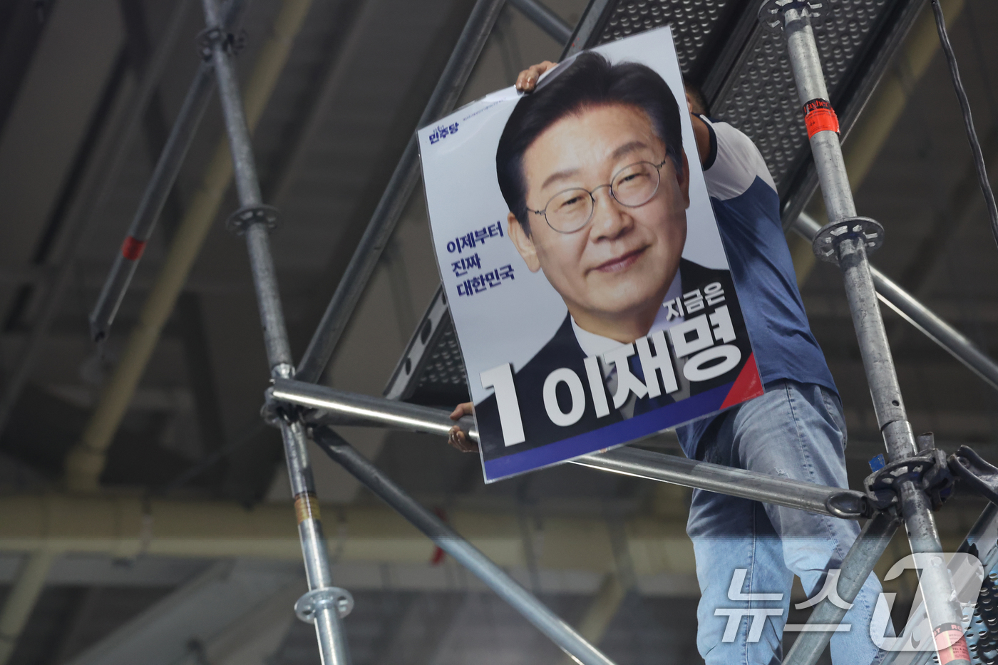 (대전=뉴스1) 황기선 기자 = 17일 오후 대전 유성구 DCC대전컨벤션센터에서 열린 '제3차 정기전국당원대회'에서 한 참석자가 비계 구조물에 올라가 소동을 벌이고 있다.  202 …