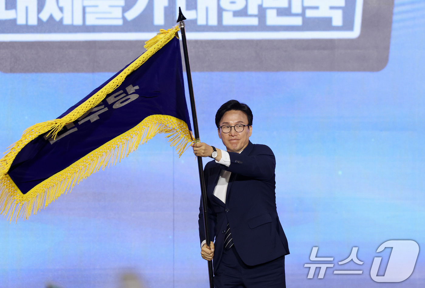 (대전=뉴스1) 황기선 기자 = 김민석 신임 더불어민주당 대표가 17일 오후 대전 유성구 DCC대전컨벤션센터에서 열린 '더불어민주당 제3차 정기전국당원대회'에서 당기를 흔들고 있다 …