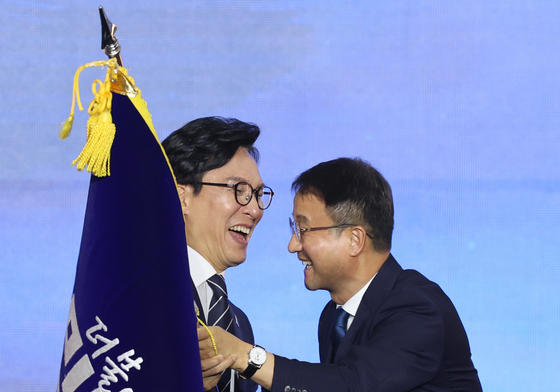 당기 건네 받는 김민석 신임 대표
