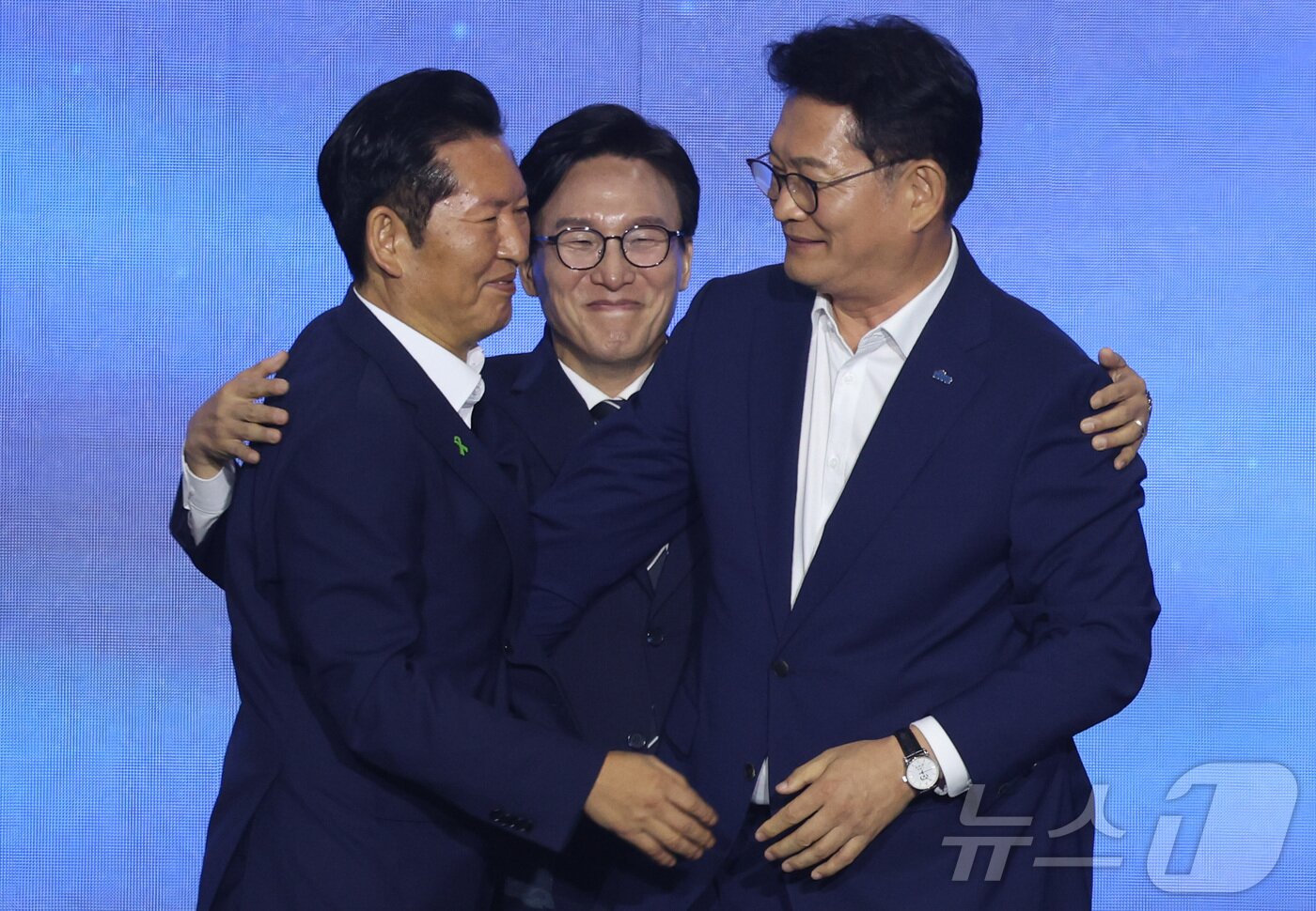 본문 이미지 - 더불어민주당 김민석 신임 당대표가 17일 대전시 유성구 대전컨벤션센터에서 열린 더불어민주당 제3차 정기전국당원대회에서 정청래, 송영길 후보의 등을 토닥이고 있다. (공동취재) 2026.8.17 ⓒ 뉴스1 황기선 기자