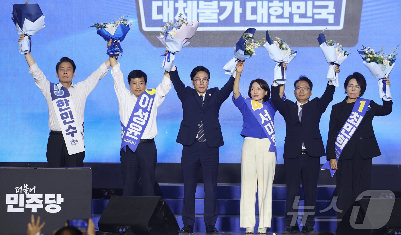 본문 이미지 - 더불어민주당 김민석 신임 당대표가 17일 대전시 유성구 대전컨벤션센터에서 열린 더불어민주당 제3차 정기전국당원대회에서 최고위원들과 함께 손을 들고 인사하고 있다. 왼쪽부터 한민수, 이성윤 최고위원, 김 대표, 서미화, 박선원, 최민희 최고위원. (공동취재) 2026.08.17 2026.8.17 ⓒ 뉴스1 황기선 기자