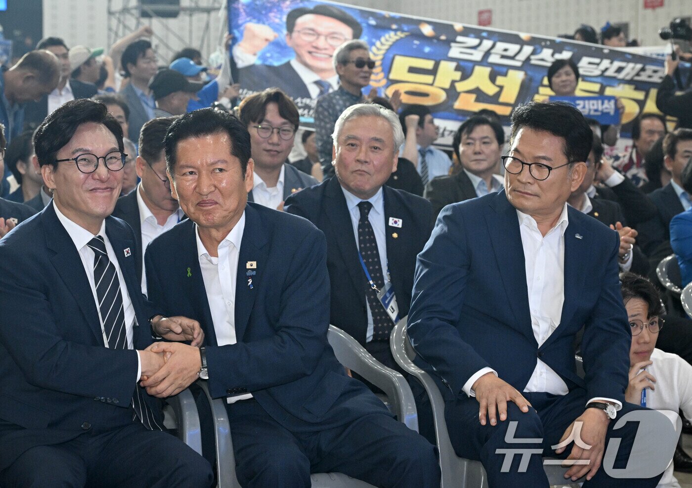 본문 이미지 - 김민석 더불어민주당 신임 당대표가 17일 대전시 유성구 대전컨벤션센터에서 열린 더불어민주당 제3차 정기전국당원대회에서 정청래, 송영길 후보의 축하를 받고 있다. (공동취재) 2026.8.17 ⓒ 뉴스1 황기선 기자