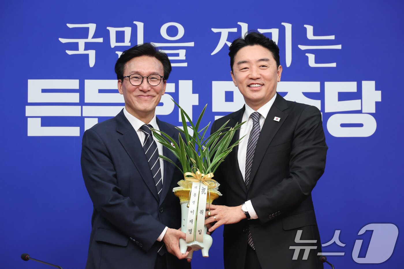 본문 이미지 - 김민석 더불어민주당 대표가 18일 서울 여의도 국회를 찾은 강훈식 대통령 비서실장으로부터 이재명 대통령의 당선 축하난을 전달받고 있다. 2026.8.18 ⓒ 뉴스1 신웅수 기자