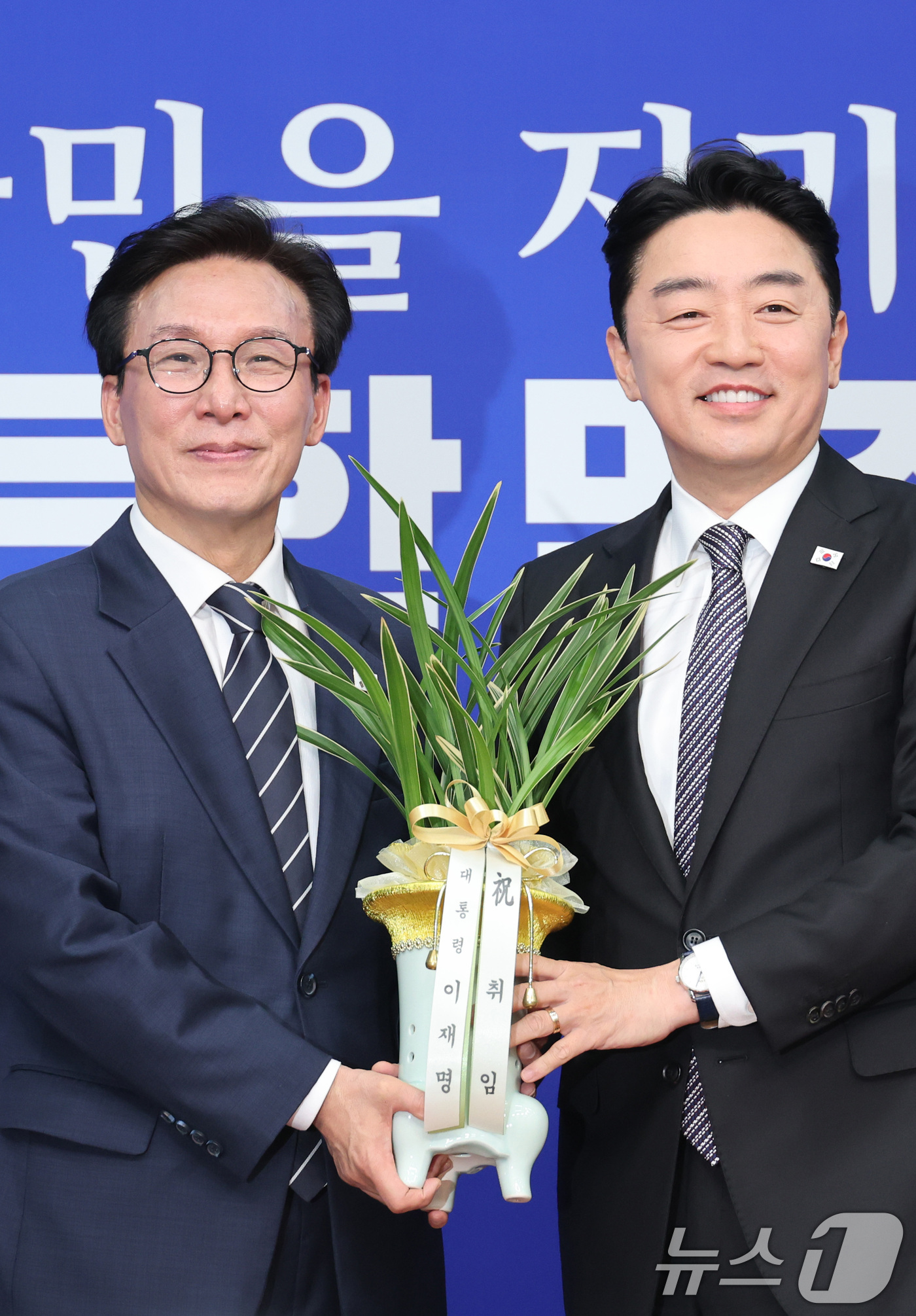(서울=뉴스1) 신웅수 기자 = 김민석 더불어민주당 대표가 18일 서울 여의도 국회를 찾은 강훈식 대통령 비서실장으로부터 이재명 대통령의 당선 축하난을 전달받고 있다. 2026.8 …