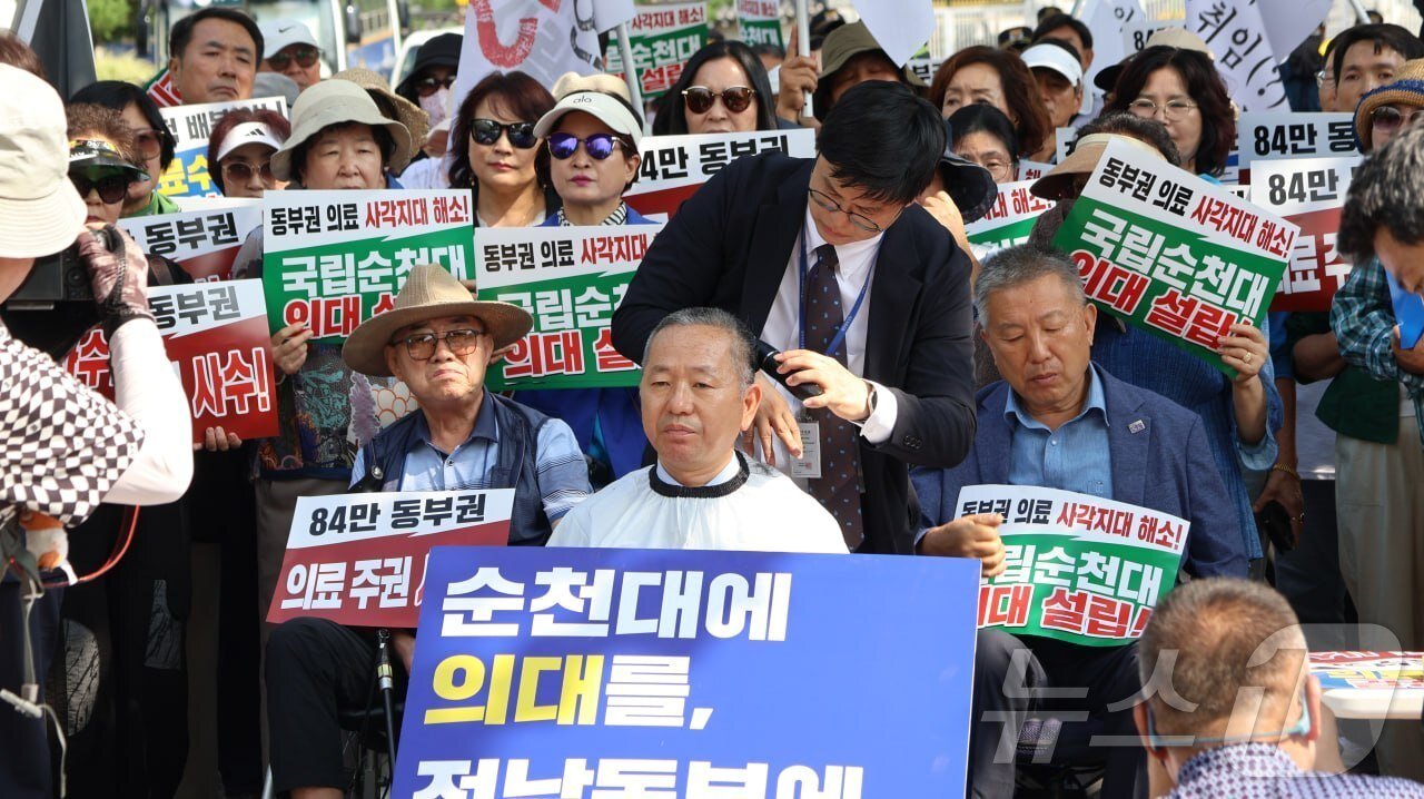 본문 이미지 - 김문수 더불어민주당 의원이 18일 청와대 앞에서 순천시민 200여명과 함께 순천대 의대와 전남동부권 대학병원 설립을 강력히 촉구하는 삭발식을 하고 있다.(김문수 의원실 제공. 재판매 및 DB금지) 2026.8.18 ⓒ 뉴스1