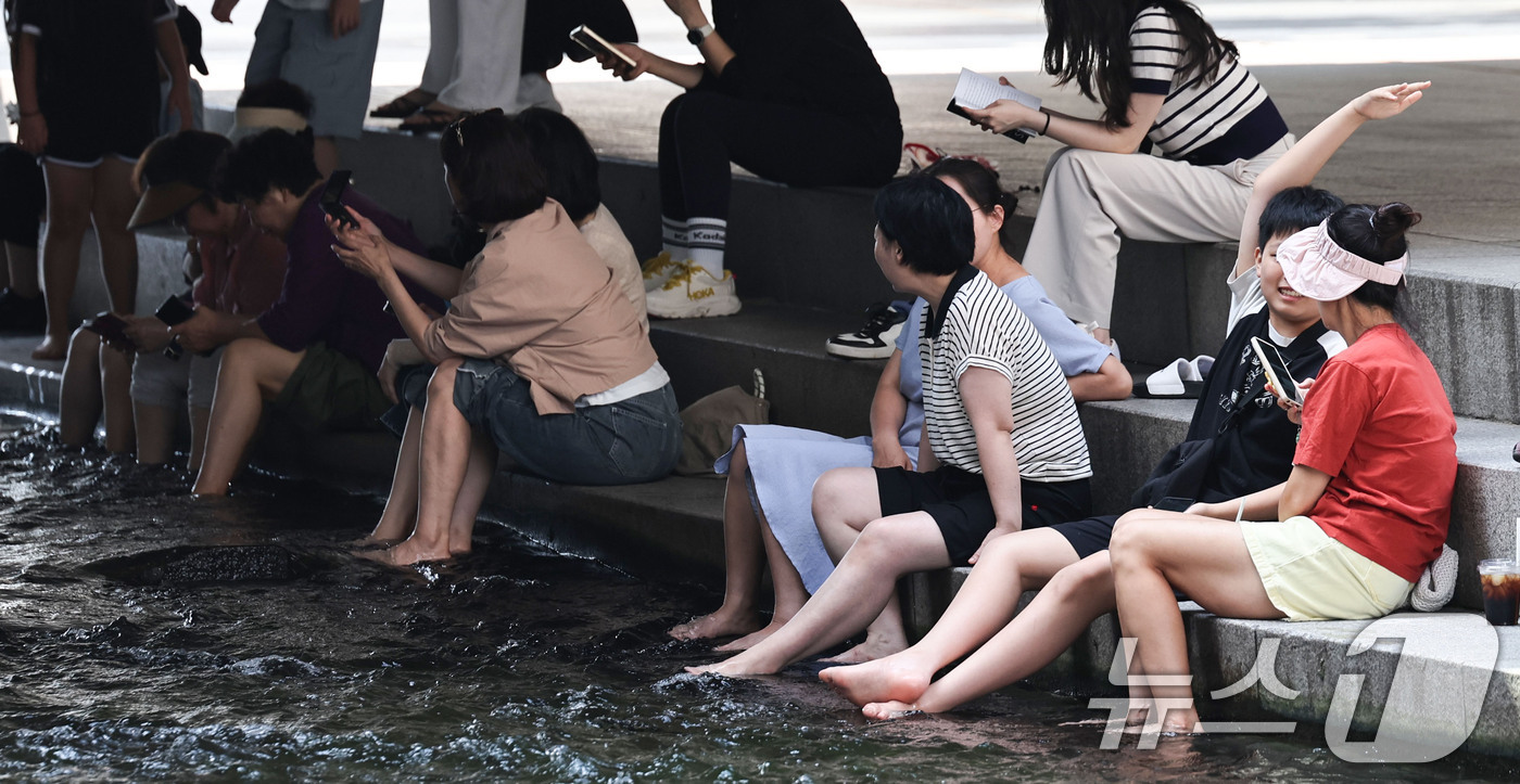 (서울=뉴스1) 이종수 기자 = 서울 일부 지역에 폭염주의보가 다시 발효된 18일 서울 청계천에서 시민들이 휴식을 취하고 있다. 이날 서울의 낮 최고기온은 32도까지 오르고 높은 …