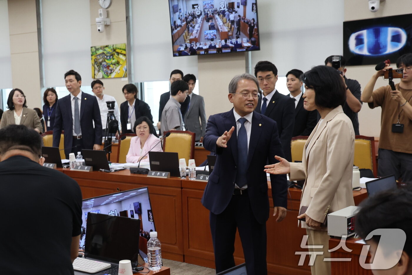 본문 이미지 - 이진숙 국민의힘 의원이 19일 오전 서울 여의도 국회에서 열린 과학기술정보방송통신위원회 전체회의에서 정회 후 송기헌 위원장과 대화를 나누고 있다.  2026.8.19 ⓒ 뉴스1 황기선 기자