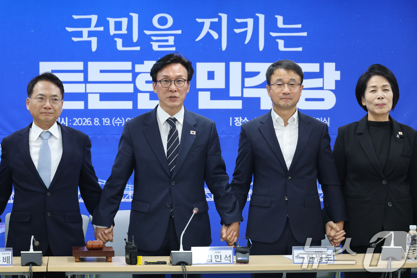 (부산=뉴스1) 신웅수 기자 = 김민석 더불어민주당 대표가 19일 부산 동구 민주당 부산시당에서 열린 현장 최고위원회의에서 한병도 원내대표, 최고위원들의 손을 잡고 발언하고 있다. …
