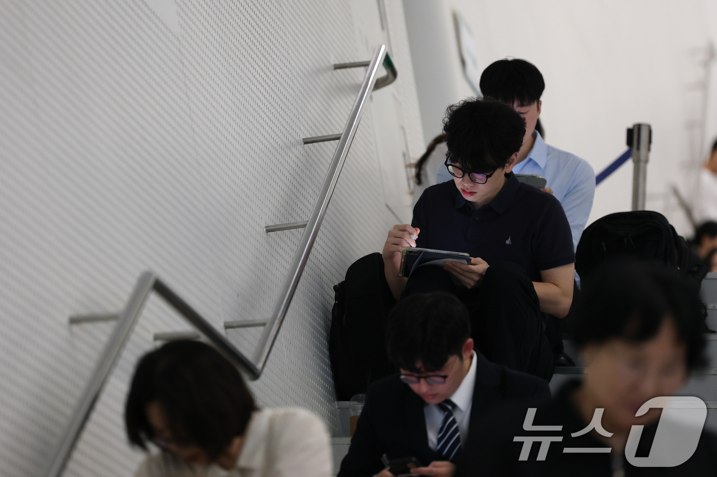 (서울=뉴스1) 안은나 기자 = 19일 서울 동대문디자인플라자(DDP)에서 열린 2026 금융권 공동채용 박람회에서 구직자들이 계단에 앉아 모의면접 등을 준비하고 있다.올해 10회 …