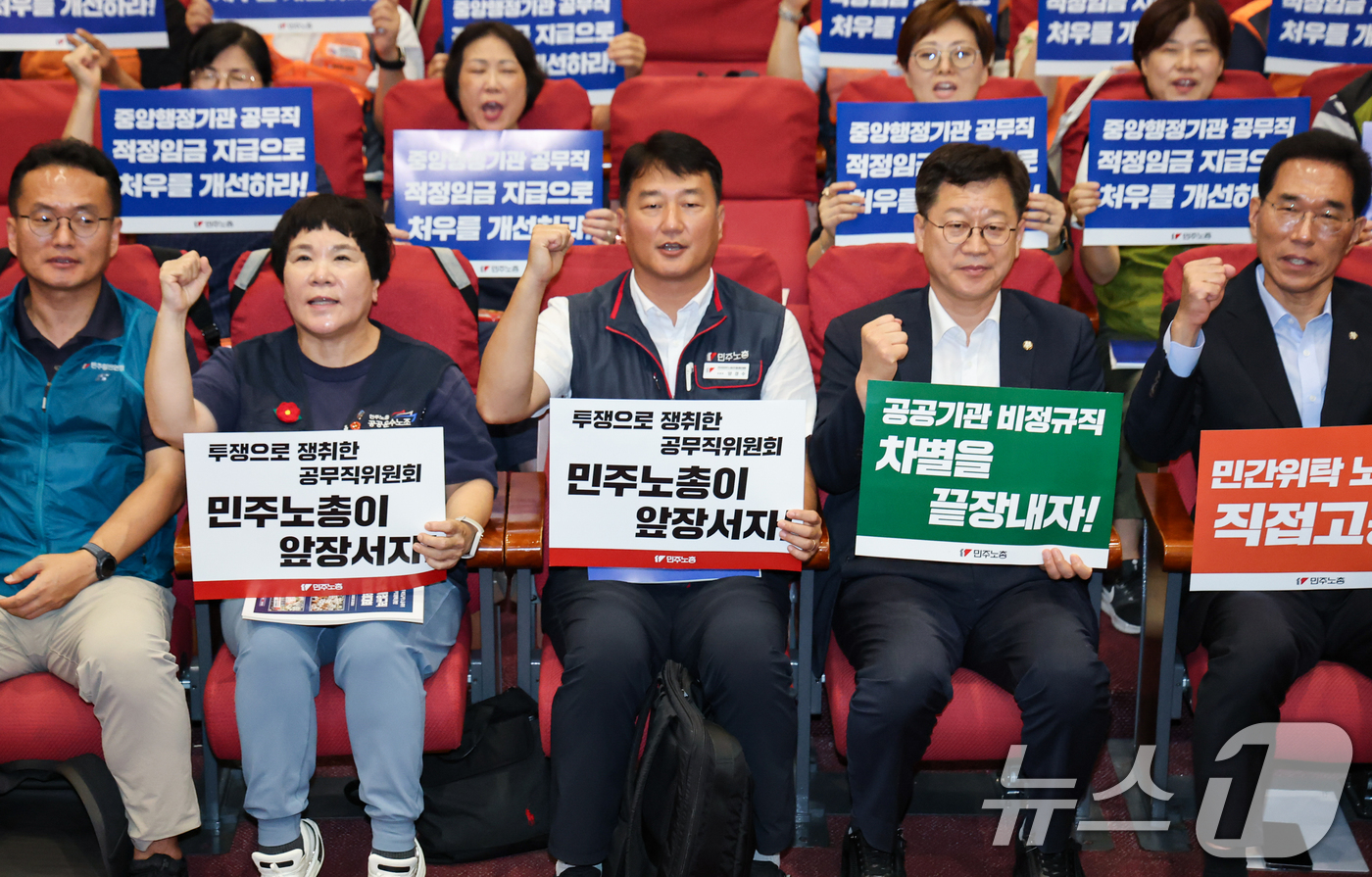 (서울=뉴스1) 김도우 기자 = 양경수 민주노총 위원장과 참석자들이 19일 서울 여의도 국회 의원회관에서 열린 민주노총 공공부문 비정규직 노동자 결의대회에서 손피켓을 들고 구호를 …