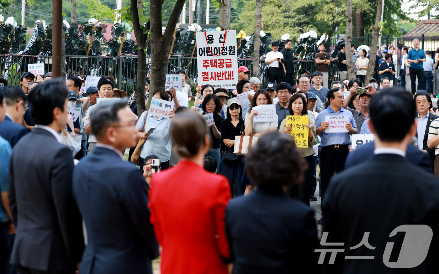 (서울=뉴스1) 이호윤 기자 = 용산 주민들이 19일 서울 용산구 한마음공원에서 열린 '용산어린이정원 사수 궐기대회‘에서 피켓을 들며 용산어린이정원 일대 주택 공급 개발을 반대하고 …