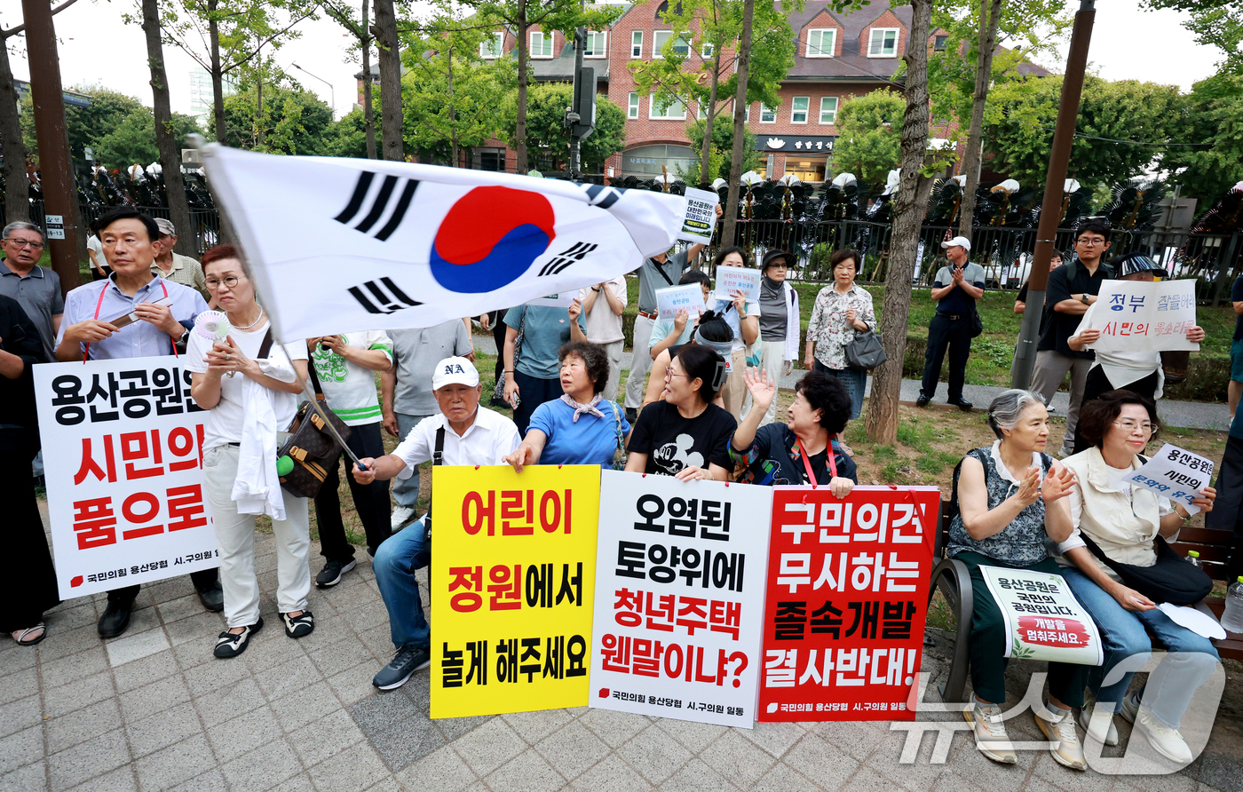 (서울=뉴스1) 이호윤 기자 = 용산 주민들이 19일 서울 용산구 한마음공원에서 열린 '용산어린이정원 사수 궐기대회‘에서 피켓을 들며 용산어린이정원 일대 주택 공급 개발을 반대하고 …